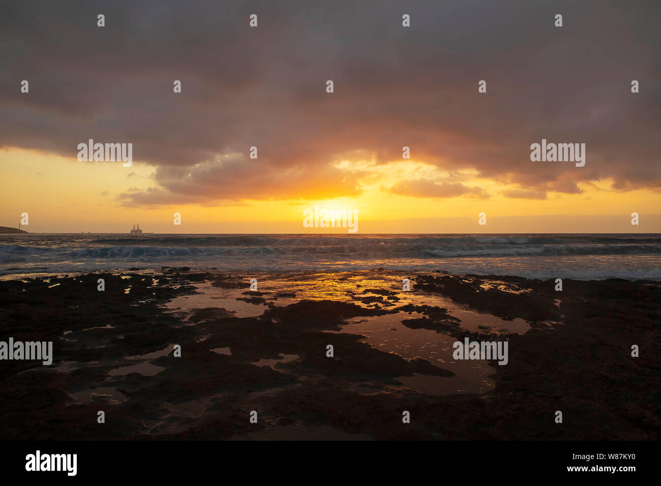 Lebendige, goldenen Sonnenaufgang über dem Kalkstein Küsten von El Medano, Teneriffa, Kanarische Inseln, Spanien. Mellow licht Sonnenaufgang über dem Atlantik. Stockfoto