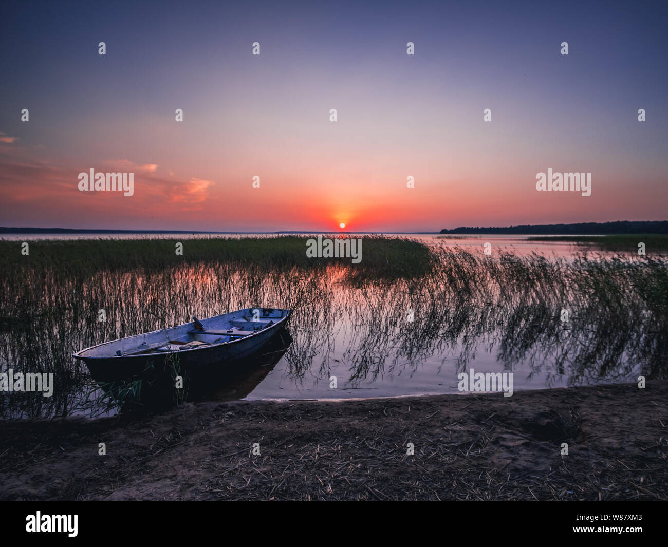 Sonnenuntergang am See, Angeln Boot am Ufer, Russland Stockfoto