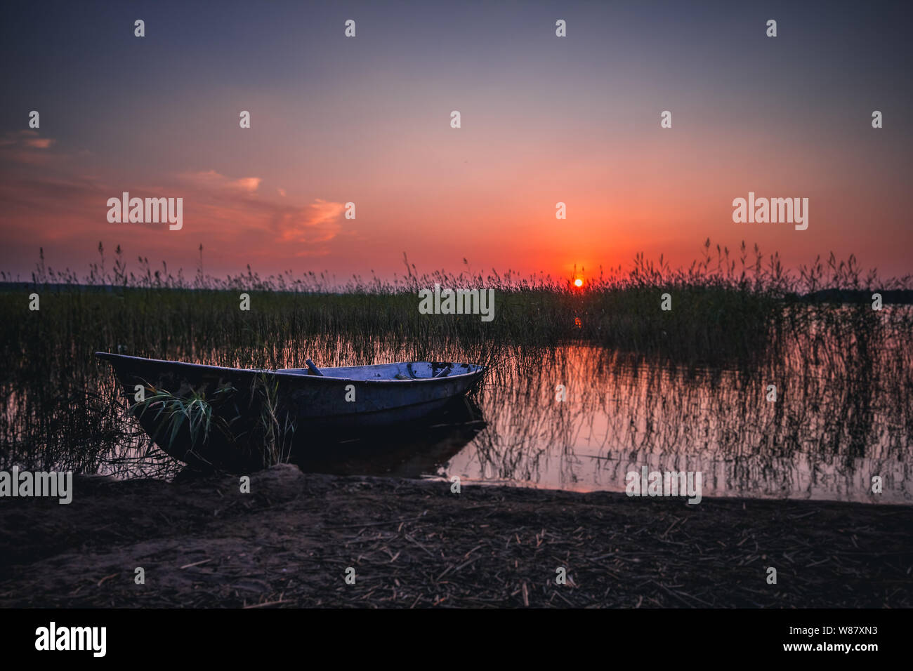 Sonnenuntergang am See, Angeln Boot am Ufer, Russland Stockfoto