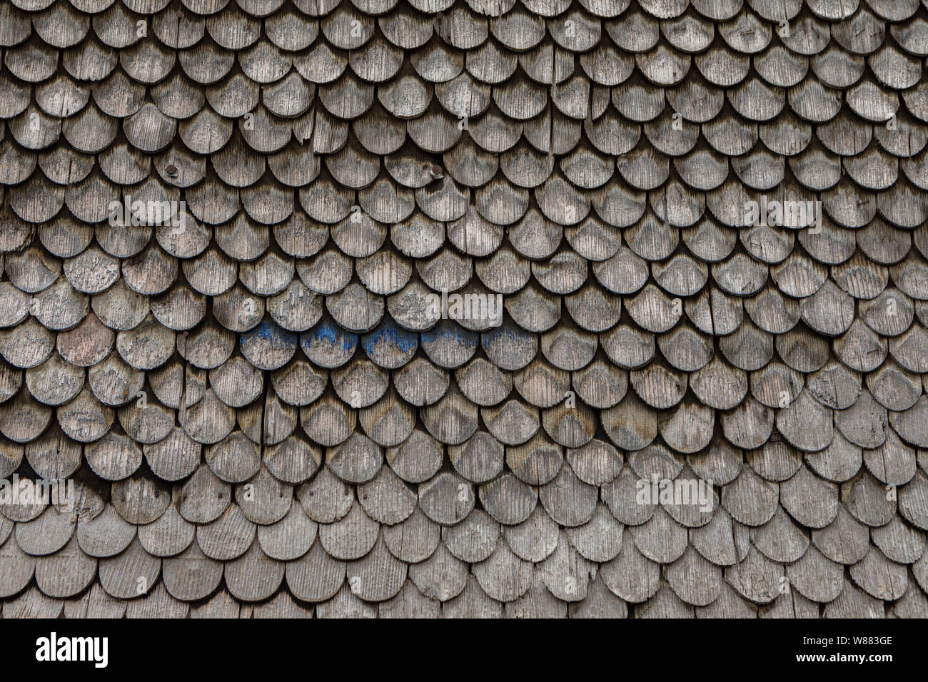 Grau verwitterte Schindeln auf einem traditionellen alpenländischen Dach Stockfoto