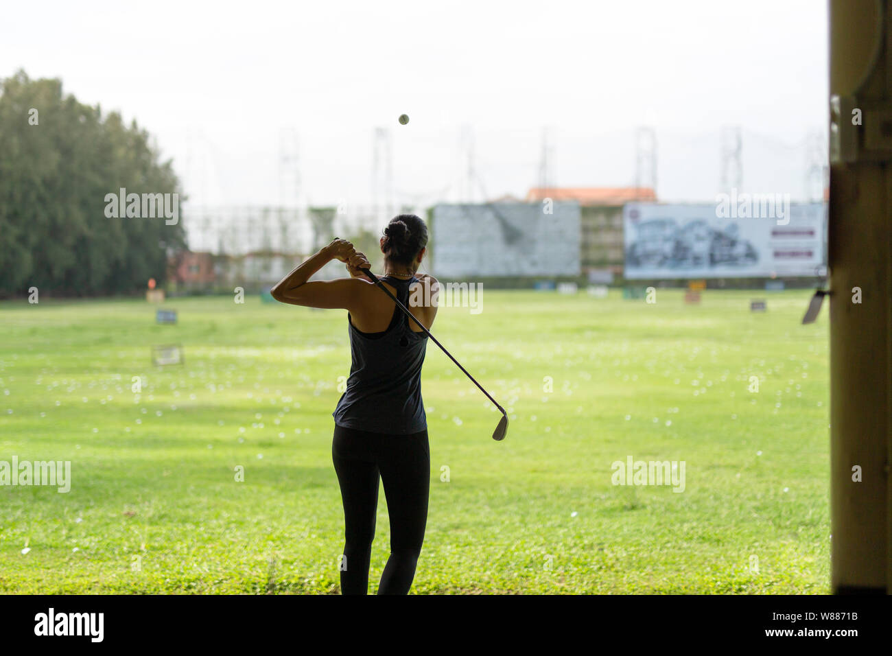 Asiatische Frau üben sein Golf Abschlag auf der Driving Range. Stockfoto
