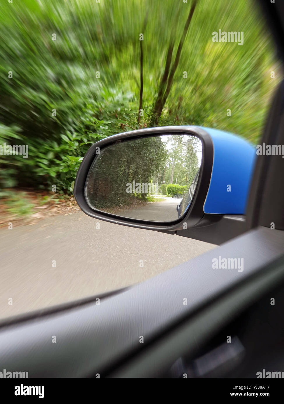 Außenspiegel Reflexion der Zweispurige kurvenreiche Straße in Wald, schöne grüne Natur Stockfoto