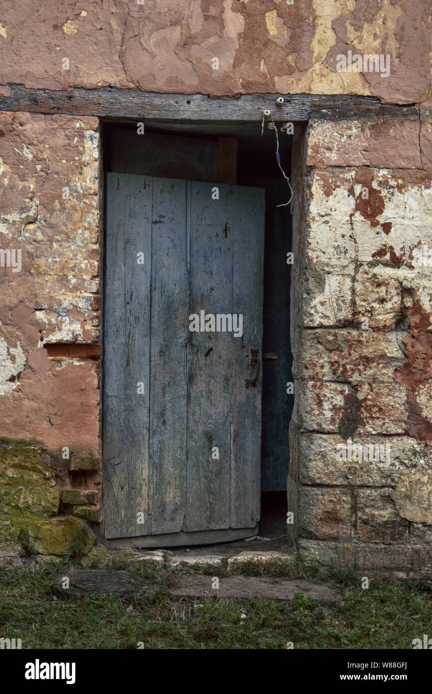 Ein verlassenes Dorf Haus mit einem halb-offenen schäbige Tür. Ein Symbol für die Verwüstung der Wirtschaft Stockfoto