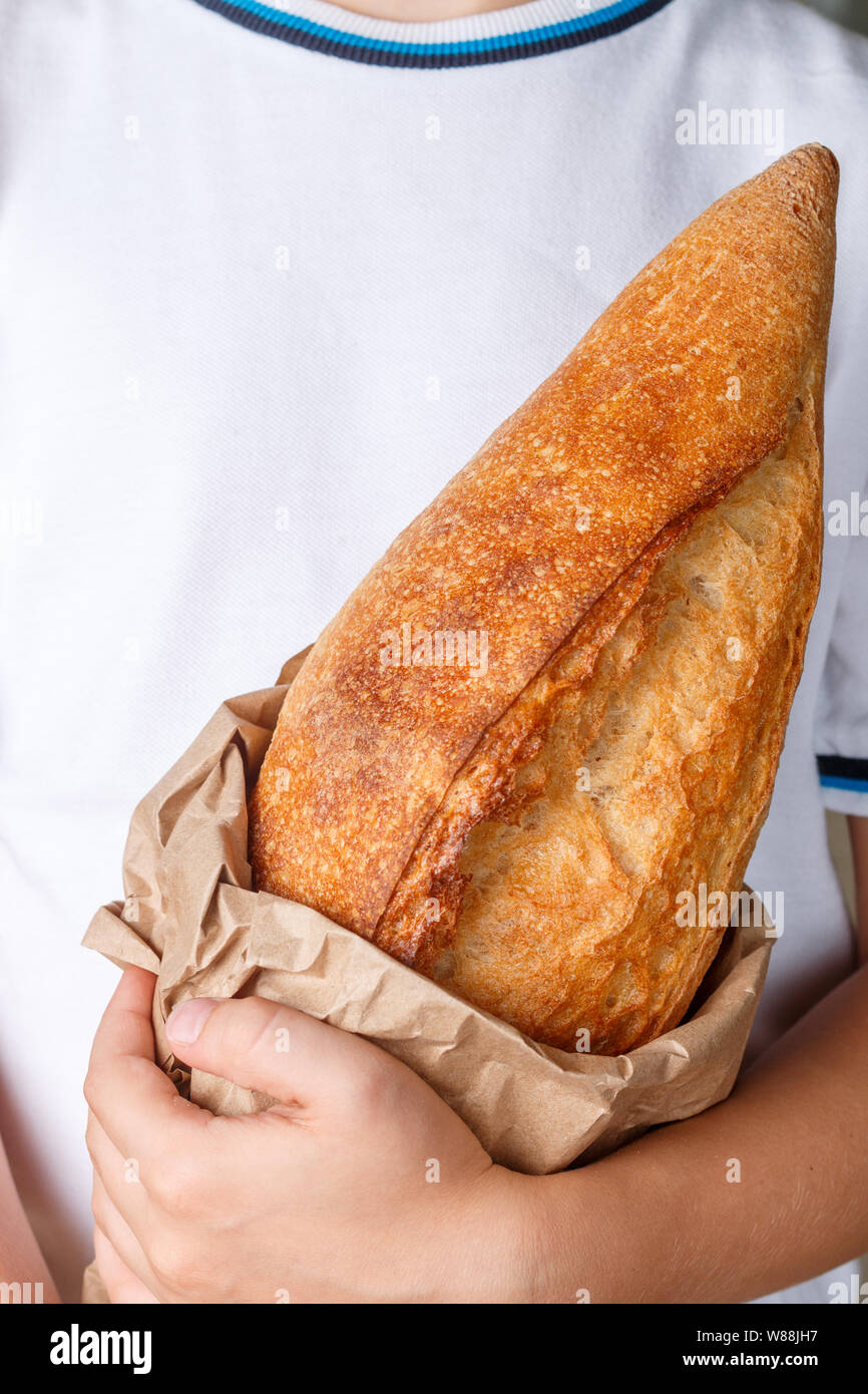 Ganzen Laib frisch gebackenes Brot aus Weizen in Kinderhand. Selektiver Fokus Stockfoto