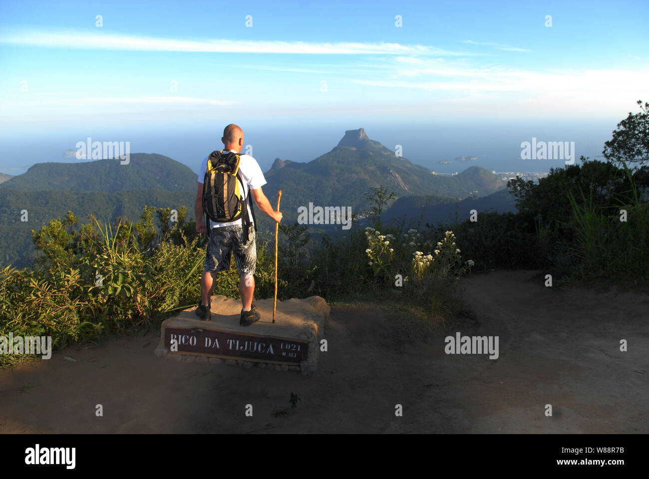 Mann in der Spitze der Pico da Tijuca, im Tijuca Nationalpark beobachtet die Ansicht von Pedra da gávea in der Stadt Rio de Janeiro Stockfoto