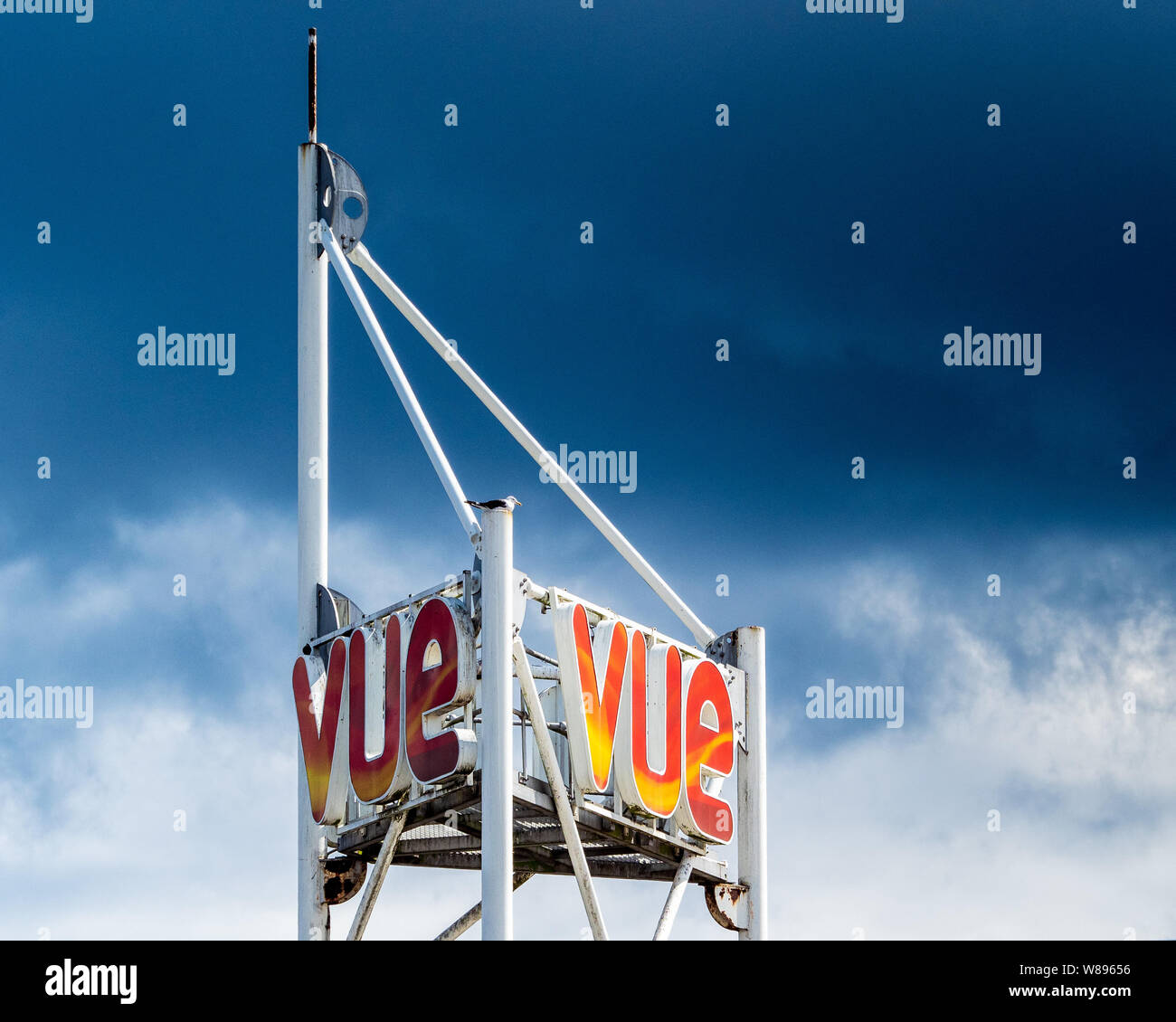 Vue Kino Logo Zeichen leuchtet bei Sonnenschein gegen einen dunklen bewölkter Himmel Stockfoto