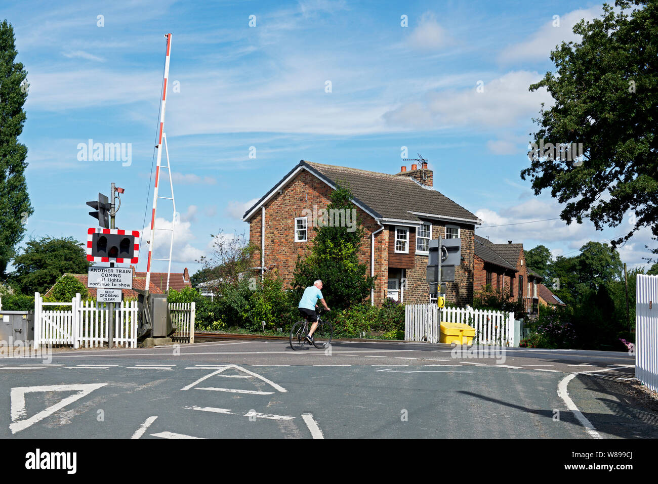 Radfahrer reiten über bahnübergang an Wressle, nahe Howden, East Yorkshire, England, Großbritannien Stockfoto