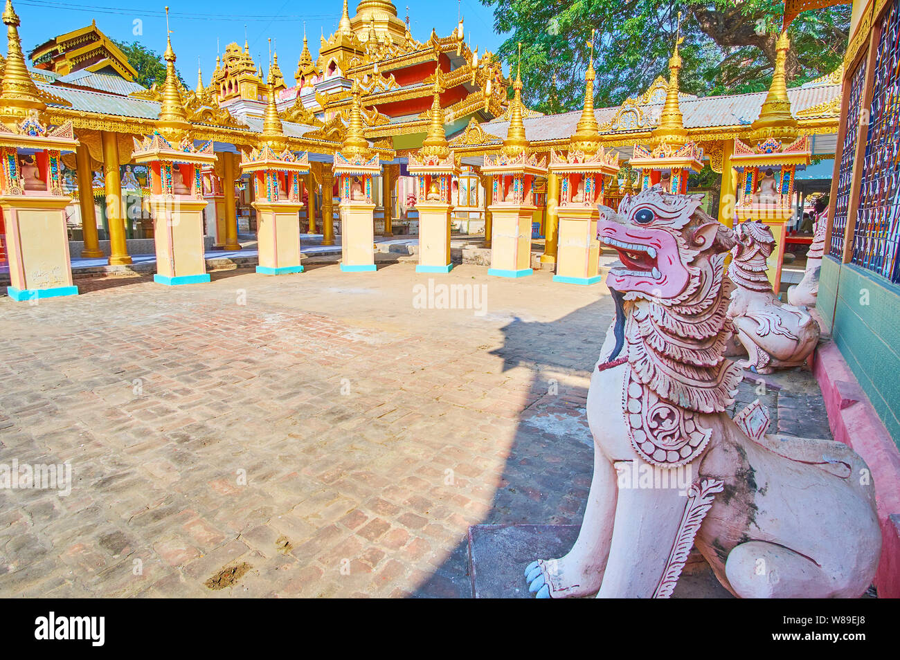 Die geschnitzten chinthe Lions vor der vergoldeten Schreine der Thanboddhay Kloster, Monywa, Myanmar Stockfoto