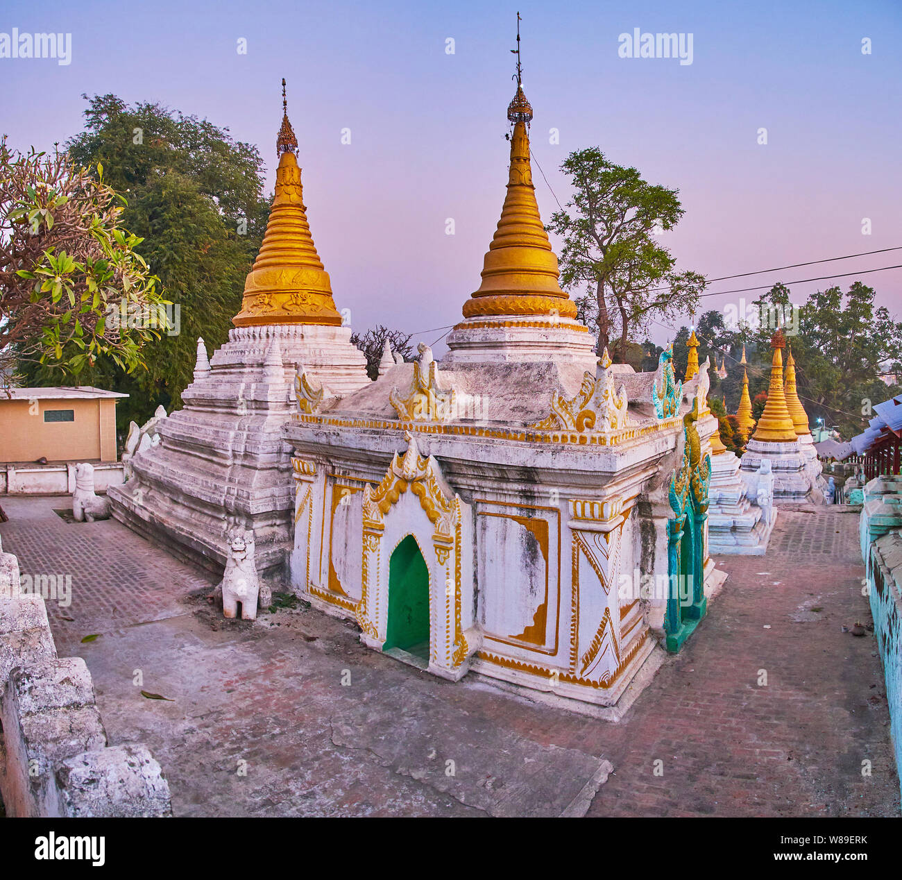 Die geschnitzten Stupas der Shwe Kyat Kya Pagode sind mit Stuckverzierungen, goldgerahmte Muster abgedeckt und gekrönt mit lacelike hti Schirme, Mandalay, Stockfoto