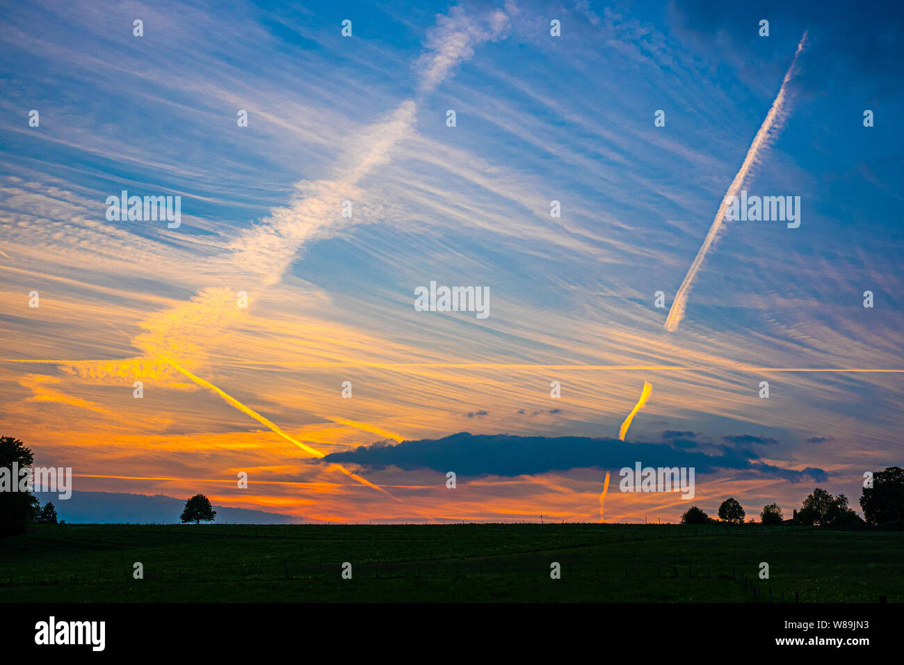 Kondensation Streifen auf bunten Abend Himmel Stockfoto
