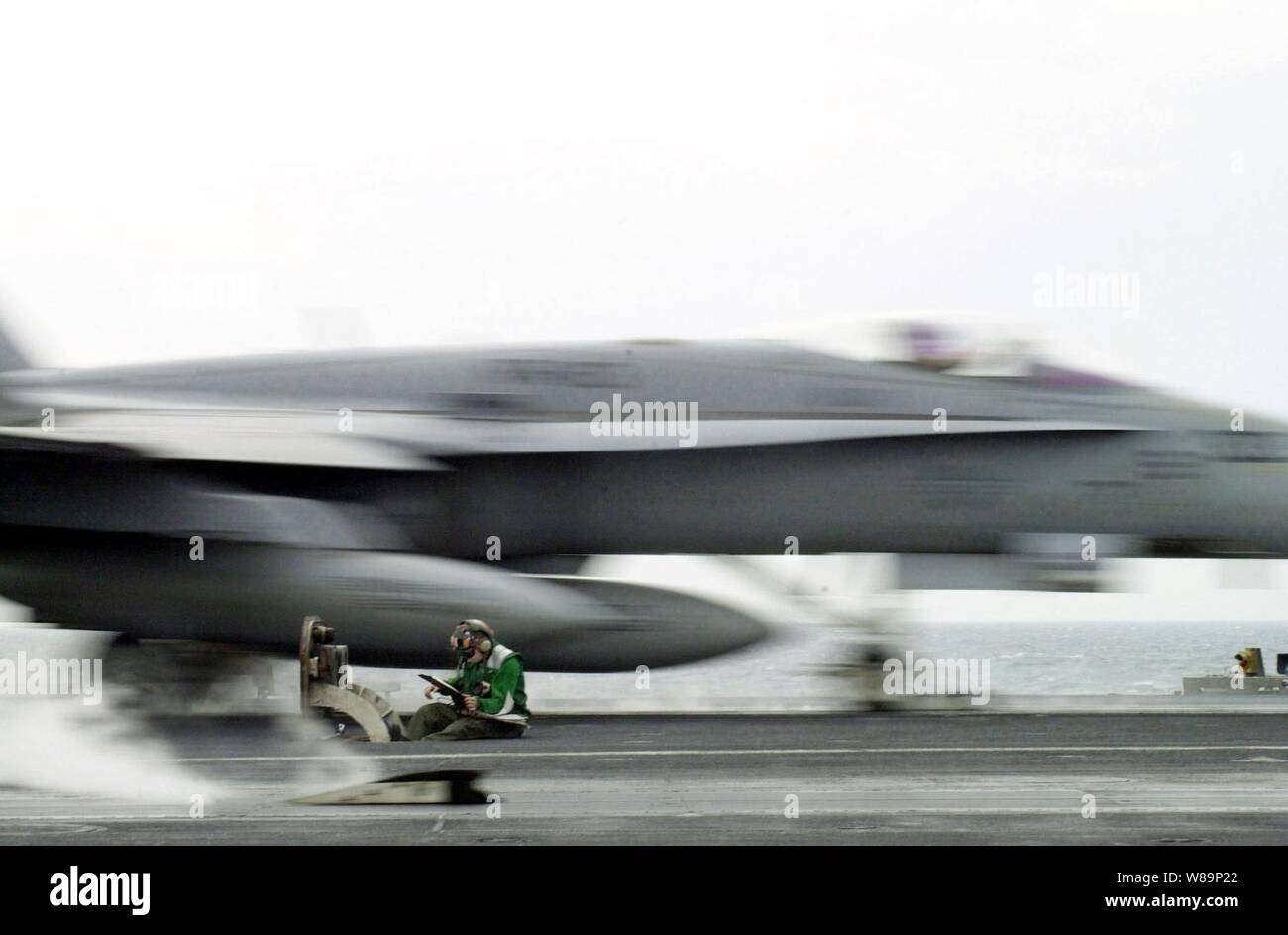 ItХs an einem anderen Tag bei der Arbeit für diese Sailor als über 20 Tonnen F-18 Hornet brüllt über seinen Kopf und weg vom Dampf Katapult der USS Abraham Lincoln (CVN 72), während das Schiff im Persischen Golf an November 3, 2000 betreibt. Diese Marine Aviation boatswainХs mate ist die Überwachung der Dampfdruck gebrauchte Flugzeuge aus dem Flight Deck des Flugzeugträgers zu starten. Lincoln und seine eingeschifft Carrier Air Wing 14, sind auf der Station im Persischen Golf zur Unterstützung der Operation Southern Watch, der USA und der Koalition die Durchsetzung der no-fly-Zone im Süden des Irak. Stockfoto