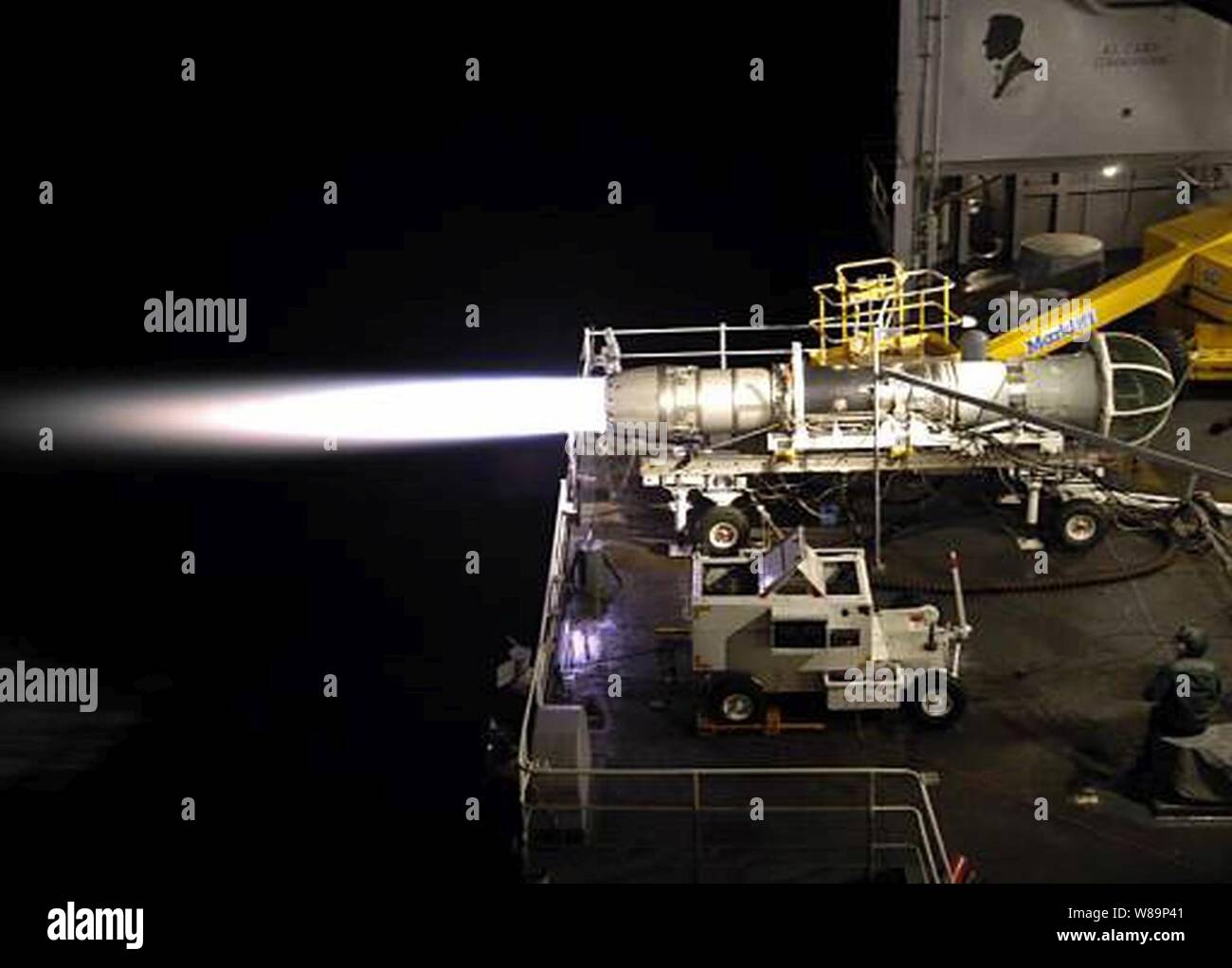 Die Flamme aus dem After Burner eines F404-GE-402 Motor durchdringt die Nacht, als der Motor auf dem fantail der USS Abraham Lincoln (CVN 72), am 23. Juni 2004 geprüft. Der Flugzeugträger führt derzeit lokale Operationen in der Vorbereitung für eine bevorstehende Bereitstellung. Stockfoto