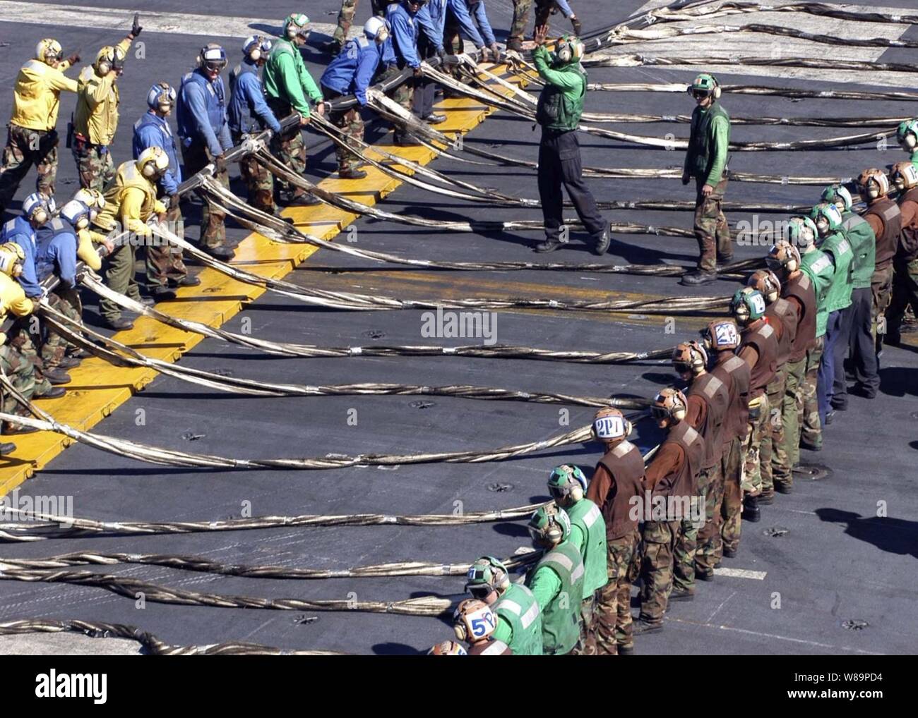 Besatzungsmitglieder an Bord des Flugzeugträgers USS Abraham Lincoln (CVN 72) bereiten die Not-landung Barrikade rig während eines Fluges deck Bohrer, wie das Schiff im westlichen Pazifik an November 18, 2004 betreibt. Die barrikade können schnell aufgeriggt und über Flight Deck eines Anbieters erhöht, ein Flugzeug, ein Fahrwerk oder tailhook Fehlfunktion zu fangen. Stockfoto