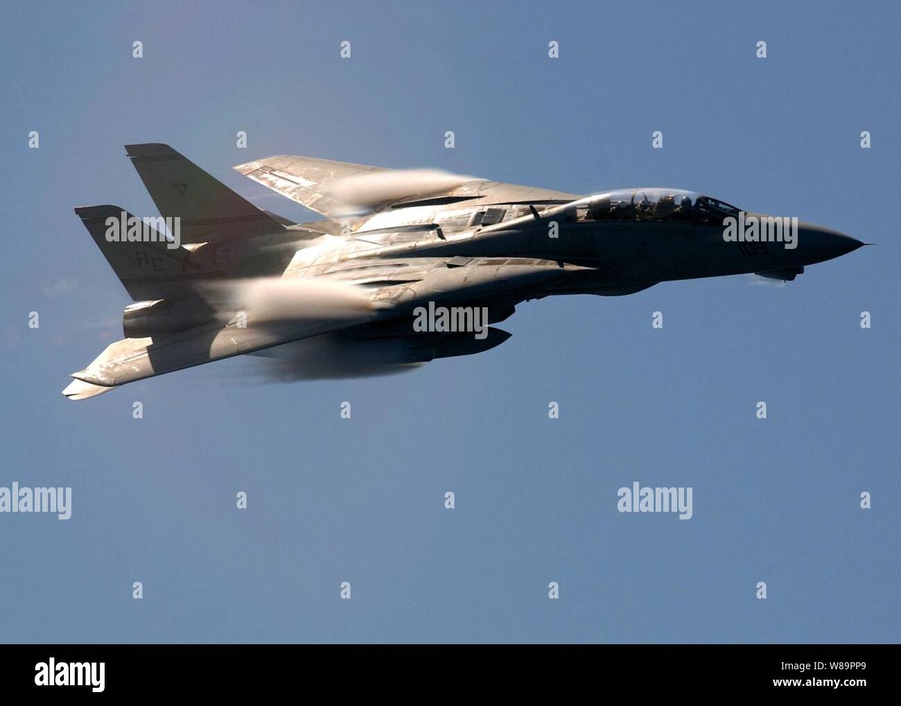 Wolken aus Wasserdampf rush über den fegte - Flügel eines Navy F-14B Tomcat als es führt eine high-speed Fly-by der Flugzeugträger USS Harry S. Truman (CVN 75) Am 30. März 2005. Die Truman Carrier Strike Group ist derzeit im Mittelmeer nachdem vor kurzem von fast vier Monate im Persischen Golf zur Unterstützung des Krieges gegen den Terror entlastet. Stockfoto