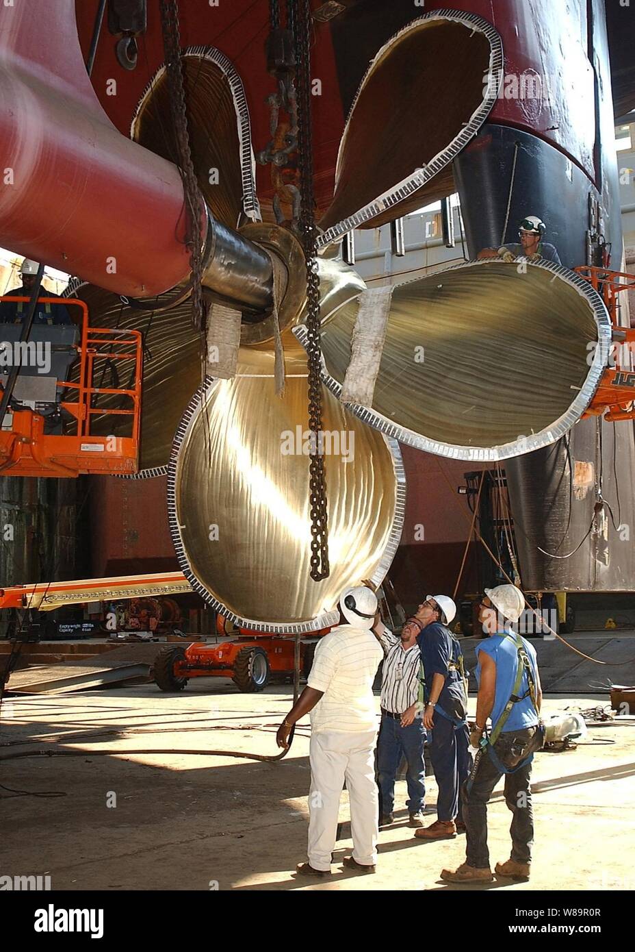 Northrop Grumman Newport News werft Mitarbeiter wieder an einem Propeller mit der Zahl 3 Welle der Flugzeugträger USS George Washington (CVN 73) in Newport News, Virginia, am 23. Juli 2005. Das Schiff verfügt über vier Messing Propeller, die sich 22 Meter im Durchmesser und 66,200 Pfund wiegen. Die Flugzeugträger der Nimitz-Klasse befindet sich in einem Angedockten geplante schrittweise Verfügbarkeit der Northrop Grumman Newport News Werft. Stockfoto