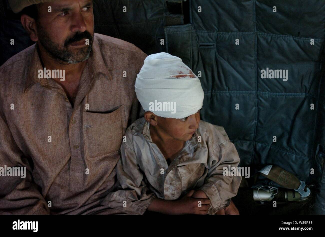 Einen pakistanischen Vater sitzt mit seinem Sohn an Bord eines U.S. Navy Sea Dragon MH-53 Hubschrauber, während Islamabad, Pakistan evakuiert werden, für die medizinische Behandlung am Okt. 17, 2005. Das Verteidigungsministerium ist die Teilnahme an der multinationalen Bemühung zu Pakistan und Indien und Afghanistan Humanitäre Hilfe und Unterstützung zur Verfügung zu stellen nach einem verheerenden Erdbeben. Stockfoto