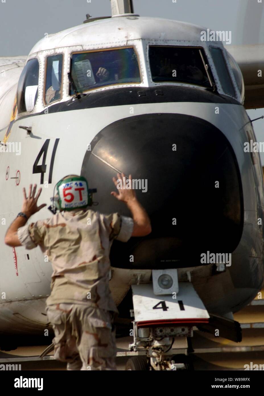 Marine Petty Officer 2. Klasse Michael Higgins Signale an der Pilot einer C-2 ein Greyhound als Bodencrew Kontrollen Schwanz den Haken des Flugzeugs vor dem Start am Februar 2, 2006. Higgins und der Greyhound sind zu Fleet Logistics Support Squadron 40, die bei der Bereitstellung von logistischer Unterstützung auf dem Flugzeugträger USS Theodore Roosevelt (CVN 71) während in den Persischen Golf beauftragt ist beigefügt. Stockfoto