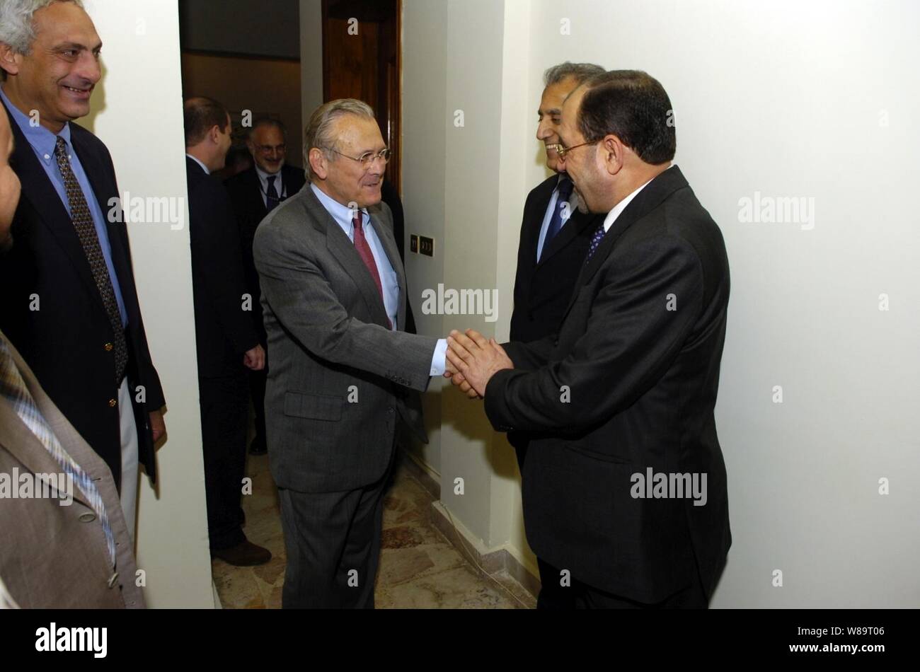 Irak des designierten Ministerpräsidenten Jawad al-Maliki (rechts) begrüßt Verteidigungsminister Donald H. Rumsfeld (links), wie sie in Bagdad, Irak, die am 26. April 2006, als US-Botschafter im Irak, Zalmay Khalilzad (Mitte) an schaut. Rumsfeld und US-Außenministerin Condoleezza Rice zu einem nicht angekündigten Besuch in den Irak gemeinsam mit al-Maliki Unterstützung für die Fortführung des Prozesses des Aufbaus der neuen irakischen Regierung zu zeigen. Rumsfeld ist auch Treffen mit hochrangigen militärischen Führer und die Truppen im Irak. Stockfoto