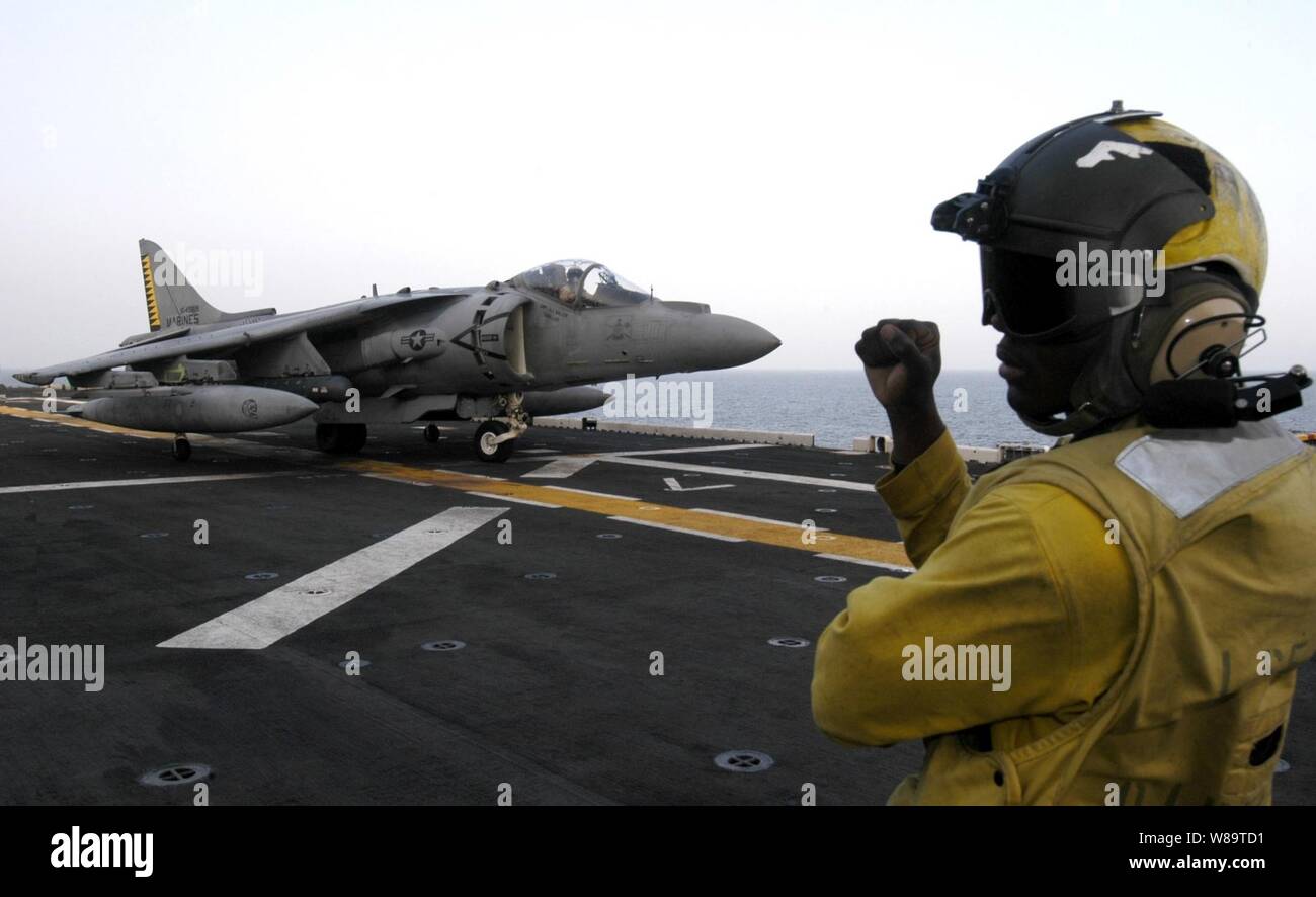 U.S. Navy Petty Officer 3. Klasse Manuel A. Paulino Signale der Pilot eines AV-8B Harrier in Position auf dem Flugdeck der USS Iwo Jima (LHD 7) Sept. 19, 2006. Die Iwo Jima begann einen sechsmonatigen Einsatz der US-European Command und US Central Command Verantwortungsbereiche Maritime Security Operations zu führen. Paulino ist ein Marine Aviation Bootsmann Mate Handler. Stockfoto