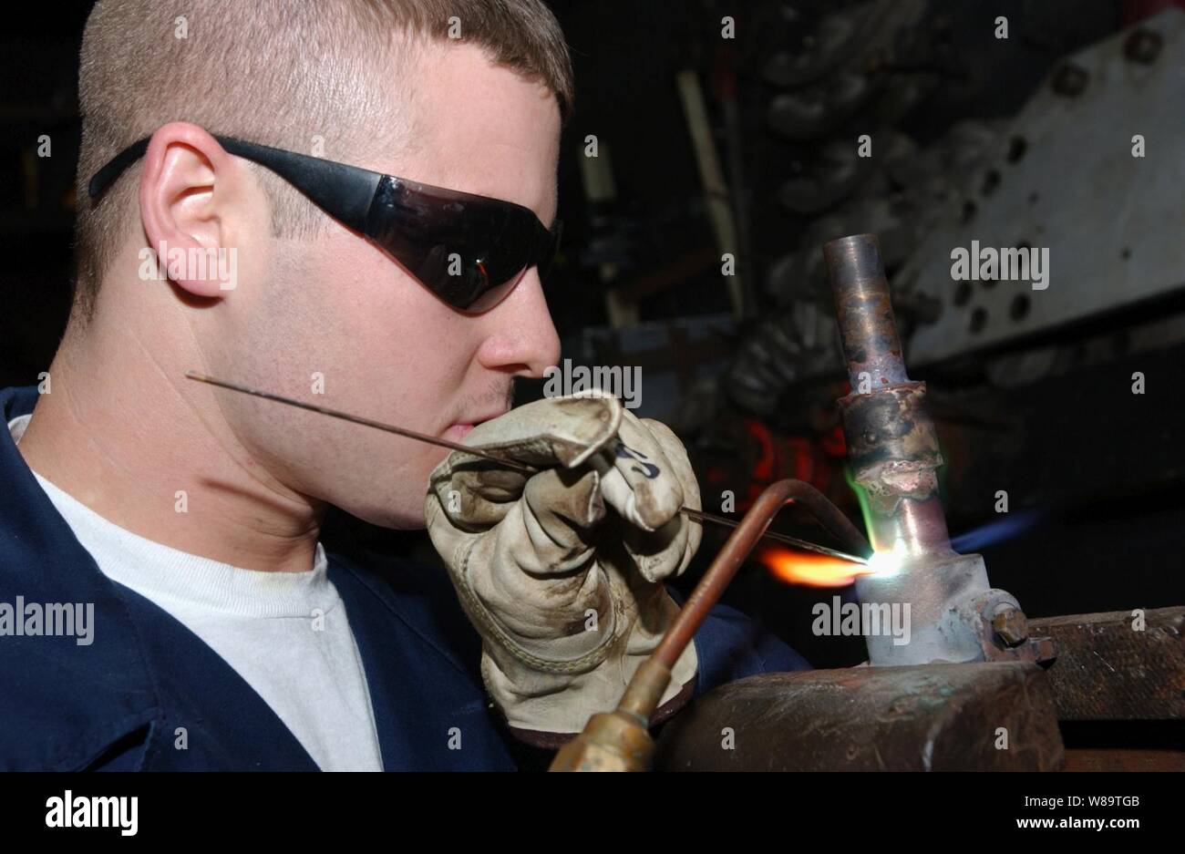 Feuerwehrmann James Sawyer brazes ein Rohr aus einem Wärmetauscher an Bord der Flugzeugträger USS Theodore Roosevelt (CVN 71) am Okt. 21, 2006. Sawyer ist ein US-Marine hull Wartungstechniker an Bord des Schiffes. Stockfoto