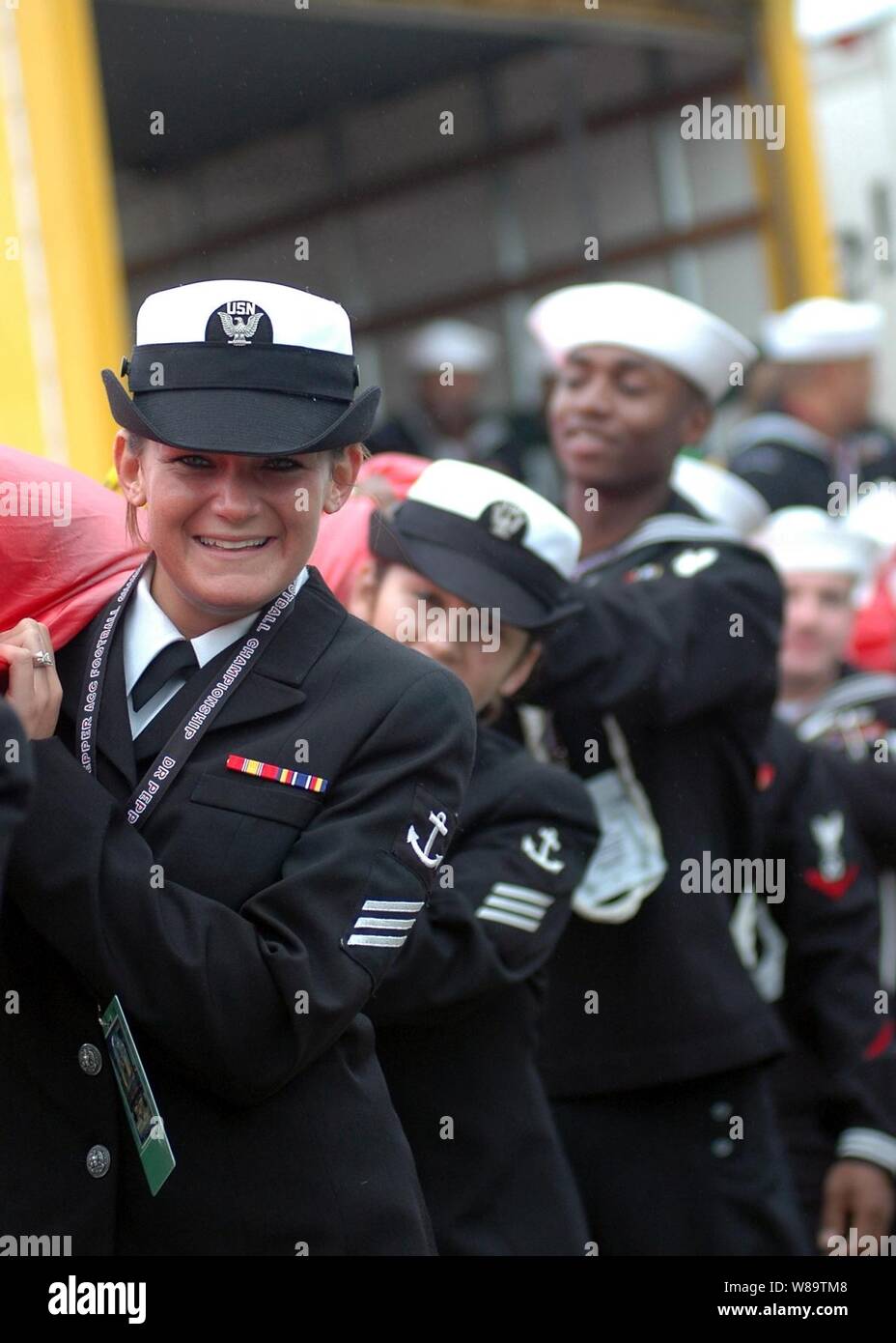 U.S. Navy Seaman Danielle Kalish (links) und andere Segler tragen die nationalen Fähnrich in Alltel Stadium vor der NCAA der Atlantic Coast Conference Championship Game in Jacksonville, Fla., am 2. Dezember 2006. Mehr als 100 Segler aus der USS John F. Kennedy (CV 67) präsentiert die Fahne vor dem Spielen der Nationalhymne. Stockfoto