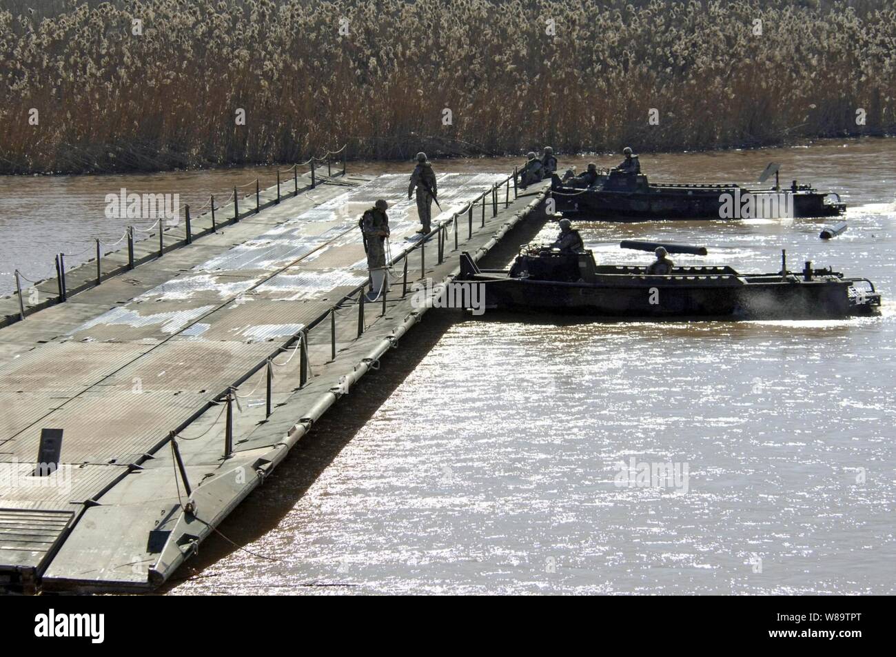 Ein Team von Boote aus dem 502Nd Multi-rolle Brücke Unternehmen, 1. Armor Division, schieben Sie einen neu zusammengesetzten Angriff float Brücke Abschnitt vordere außerhalb Camp Taji, Irak, Jan. 11, 2007. Stockfoto Ein Team von Boote aus dem 502Nd Multi-rolle Brücke Unternehmen, 1. Armor Division, schieben Sie einen neu zusammengesetzten Angriff float Brücke Abschnitt vordere außerhalb Camp Taji, Irak, Jan. 11, 2007. Stockfoto