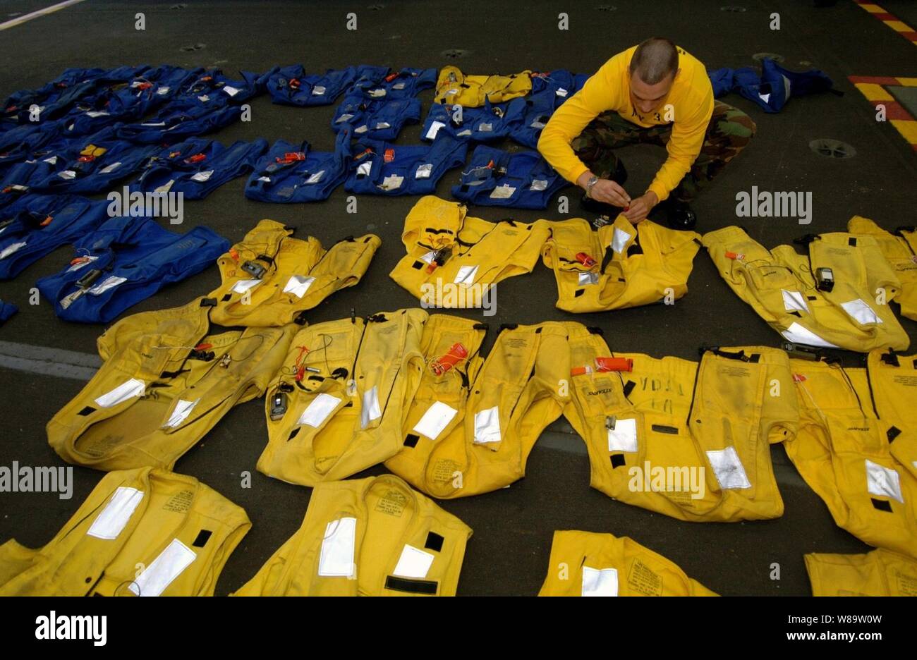 U.S. Navy Petty Officer 3rd Class Louis Perone durch jedes float Coat geht für einen Notruf licht Marker, Dye Marker zu prüfen, Pfeifen, und Inflation Rohr an Bord der Flugzeugträger USS Harry S. Truman (CVN 75) während in den Atlantischen Ozean am 5. Juli 2007. Die farbigen float Mäntel sind persönliche floatation Geräte. Truman ist unterwegs in den Atlantischen Ozean an einem Composite Trainingsgerät Übung in Vorbereitung für einen Einsatz in den Persischen Golf. Stockfoto