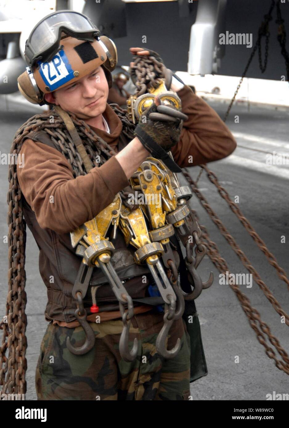 U.S. Navy Airman Tommy Allen Transporte mehrere tie-down-Ketten über das Flight Deck der Flugzeugträger USS Harry S. Truman (CVN 75) als das Schiff arbeitet im Persischen Golf auf Jan. 3, 2008. Der tie-down-Ketten zu sichern Flugzeuge auf das Deck des Schiffes verwendet sie am Bewegen zu hindern. Truman und schiffte sich Carrier Air Wing 3 auf den Weg in den Persischen Golf zur Unterstützung der Operationen Iraqi Freedom und Enduring Freedom und Maritime Security Operations. Stockfoto