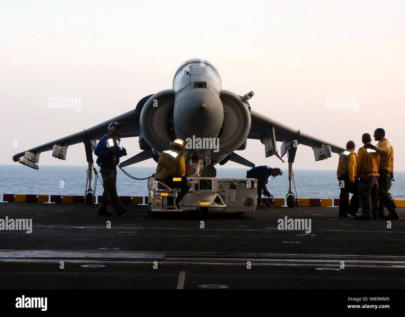U.S. Navy's Aviation Bootsmann Mate Petty Officer 3rd Class Brandt Krauel und andere Segler aus der Luft Abteilung direkt ein AV-8B Harrier Flugzeuge in Position auf einen Aufzug mit einem Spotting dolly an Bord der Amphibisches Schiff USS Peleliu LHA (5) während der Fahrt in den Pazifischen Ozean am 15. Mai 2008. Stockfoto