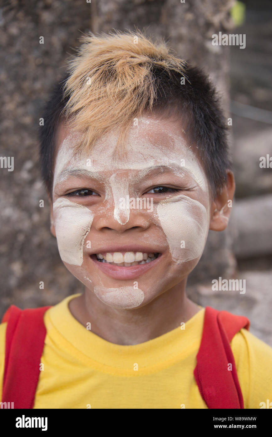 Eine junge Glücklich burmesischen Junge mit dem traditionellen Thanaka Make-up auf Was ist ein Sonnenschutz weisse Paste und aktuelle Frisur in Bagan in Myanmar. Stockfoto