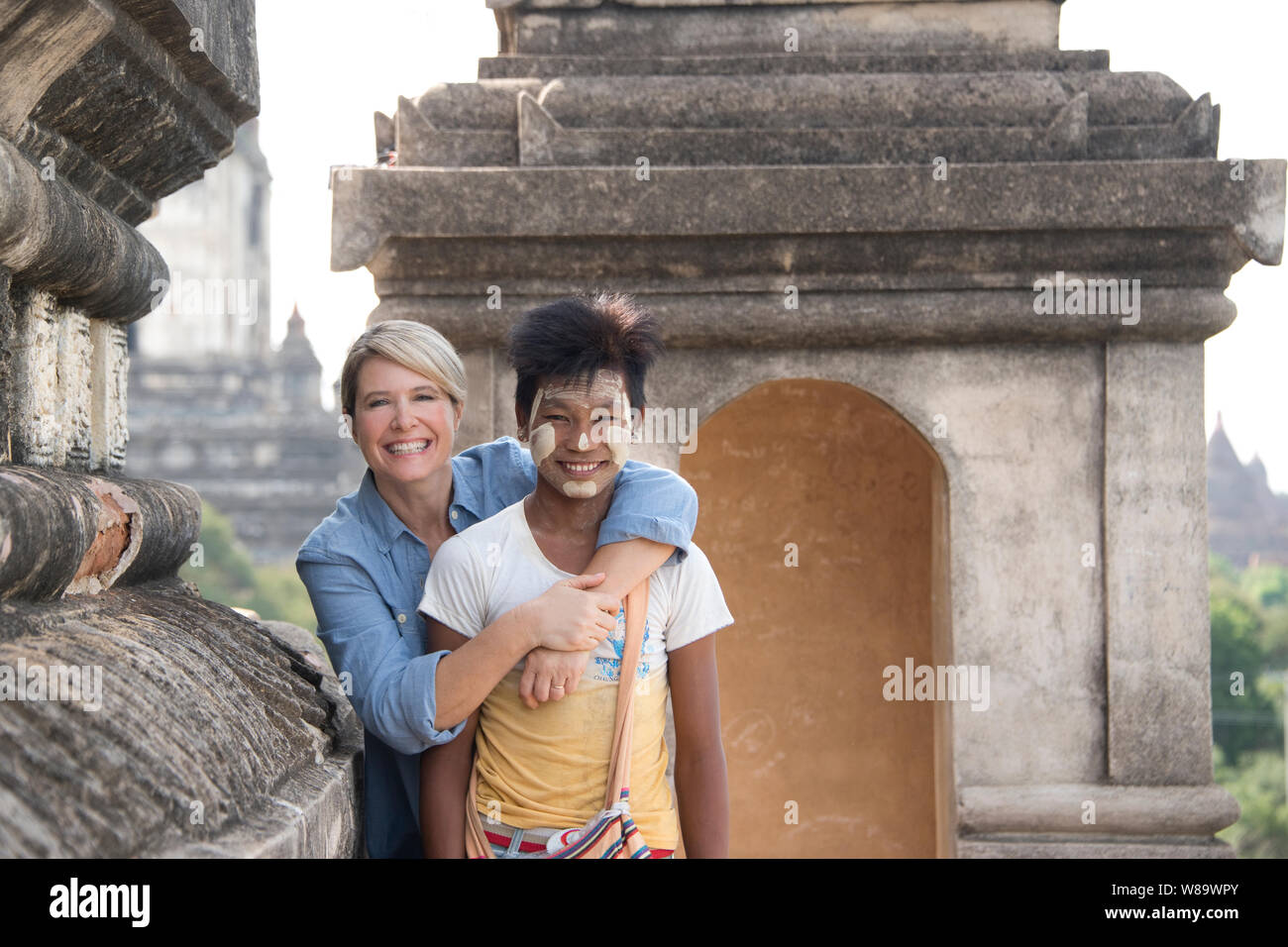 Ein sehr glückliches Weiblichen kaukasischen Touristische und Birmanische Junge mit den traditionellen Thanaka Make-up eine Weiße kosmetische Einfügen in Bagam Myanmar-Woman freigegeben. Stockfoto