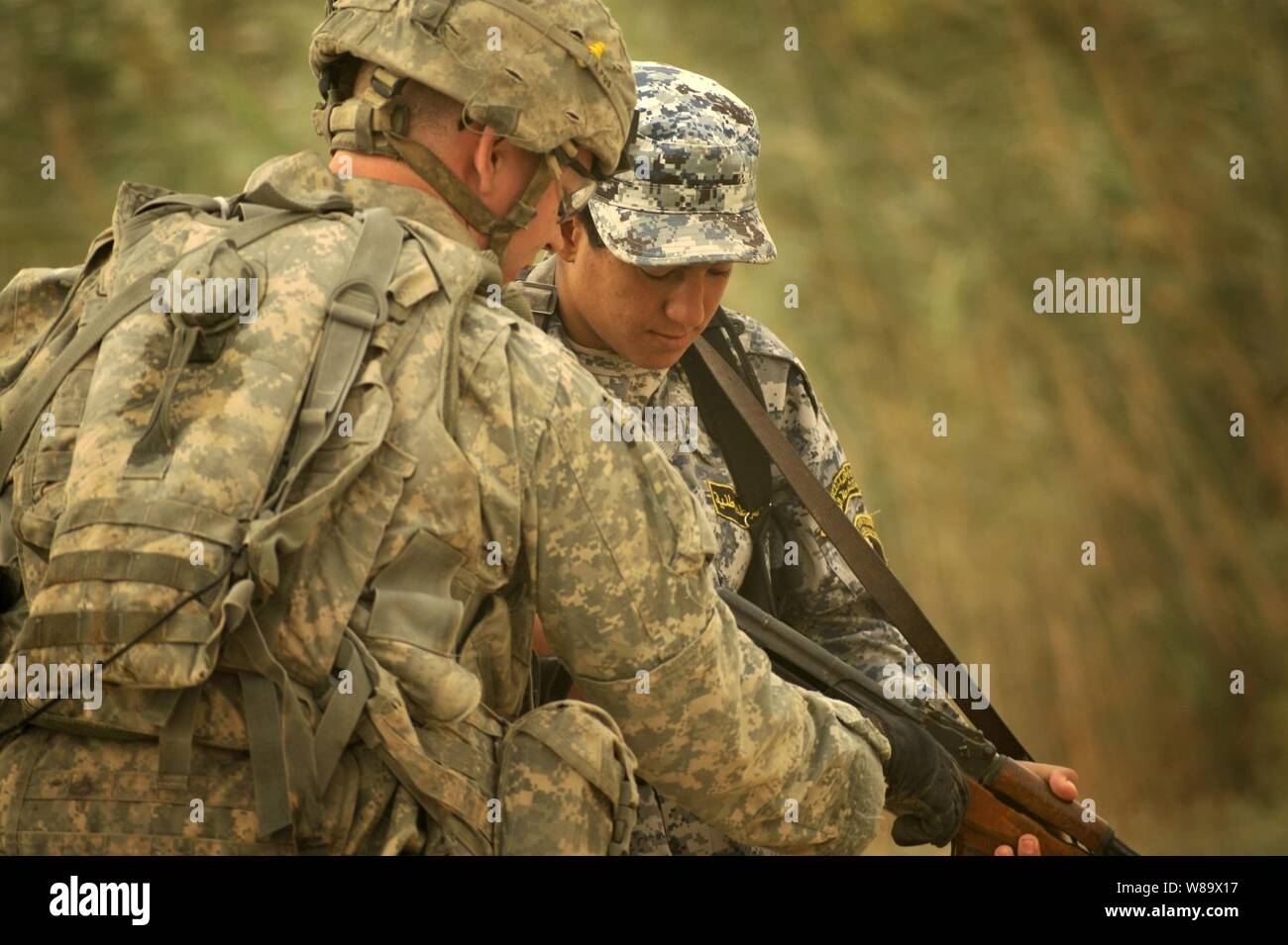 Ein Soldat der US-Armee in die 4 Infanterie Division angehängten zeigt eine irakische Soldaten Waffe - Handhabung während einer Patrouille in Abu T'S hir, Irak, am Okt. 16, 2008. Stockfoto