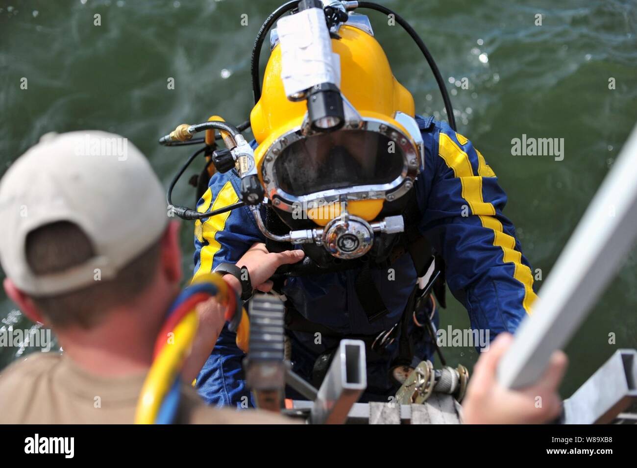 U.S. Navy Petty Officer 1st Class Eric Riggenbach, Mobile Tauchen und Bergung Einheit 2 zugewiesen, klettert an Bord einer ugandischen Zivilluftfahrtbehörde Rettungsboot nach einem Tauchgang in Afrikas Lake Victoria in Entebbe, Uganda, am 29. März 2009. Der Tauchgang war Teil der Combined Joint Task Force-Horn von Afrika Mission für und möglicherweise zu Wracks von einer Iljuschin 76 cargo Flugzeug, das in den See stürzte am 9. März suchen. Stockfoto