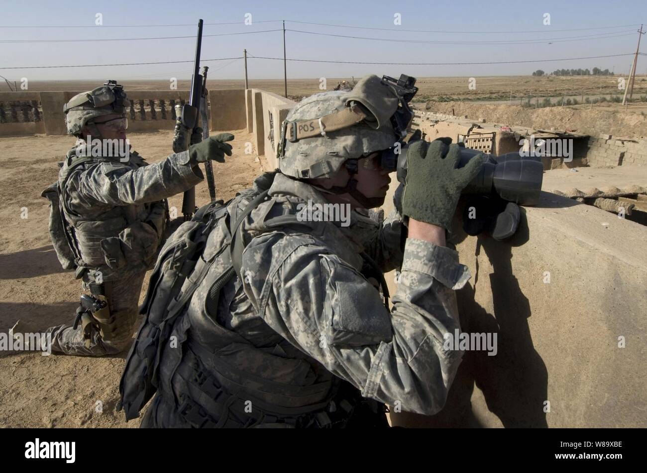 Us-Armee Cpl. Tim Garrett (links) und SPC. Jakob Collins von Recon Platoon, 1.Bataillon, 24 Infanterie Regiment, 1 Stryker Brigade Combat Team, 25 Infanterie Division bieten Sniper über beobachten, während der Abstand des Dorfes Shuzayf, Irak, am 26. März 2009. Stockfoto