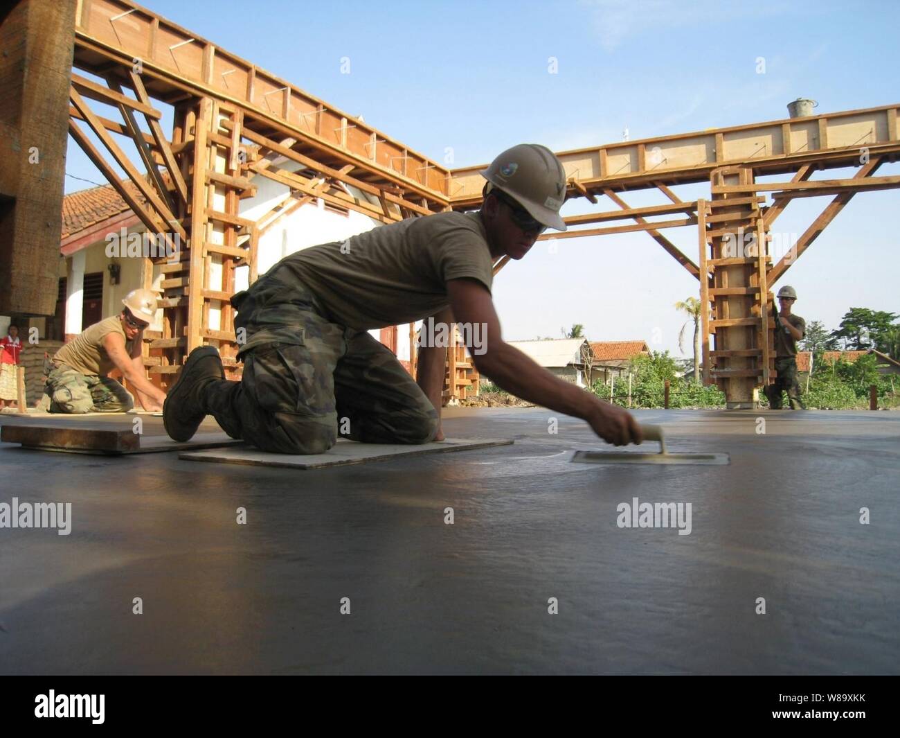 U.S. Navy Petty Officer 2nd class Eric George, zu Naval Mobile Konstruktion Bataillon 40 zugewiesen wurde, verwendet eine Kelle aus einem konkreten Gebäude Platte für eine neue multiuse Gebäude an Pusaka Rakyat Grundschule in Bekasi, Indonesien zu glatt, während der ersten Phase der Zusammenarbeit flott Bereitschaft und Weiterbildung Indonesien 2009 am 29. Juli 2009. Zusammenarbeit flott Bereitschaft und Training ist eine Reihe von bilateralen Übungen jährlich in Südostasien statt Beziehungen zu stärken und die Einsatzbereitschaft der beteiligten Kräfte zu erhöhen. Stockfoto