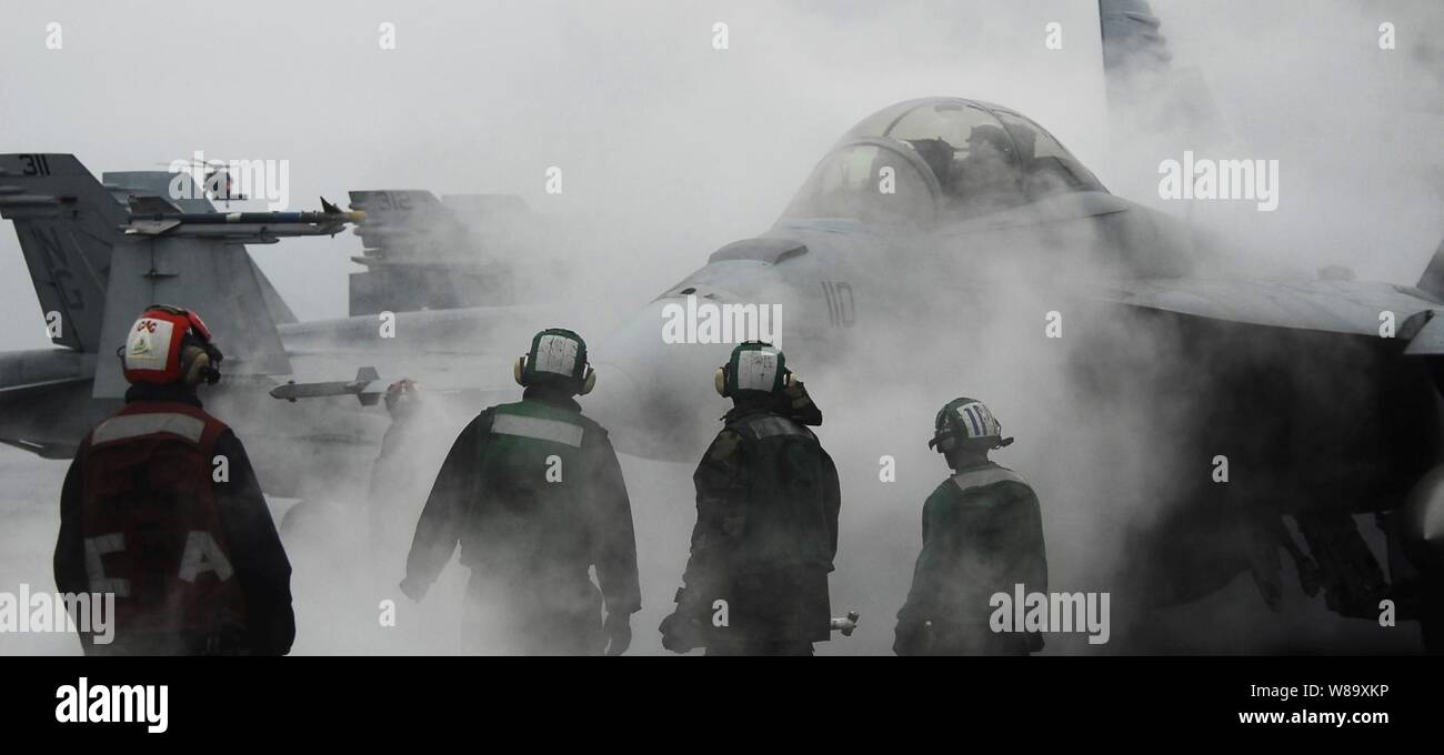 U.S. Navy Flight Deck personal Guide eine F/A-18F Super Hornet Flugzeuge von Strike Fighter Squadron 154 auf ein Katapult auf dem Flugdeck an Bord der Flugzeugträger USS John C Stennis (CVN 74) während eines Carrier Air Wing 9 Fliegen, in den Pazifischen Ozean am 3. Juli 2009. Die Stennis ist auf dem Weg nach San Diego Carrier Air Wing 9 vor der überschrift zurück zu seinen Heimathafen von Bremerton, Washington Die Stennis ist wieder von einem sechsmonatigen Einsatz in den Westpazifik zu verlagern. Stockfoto