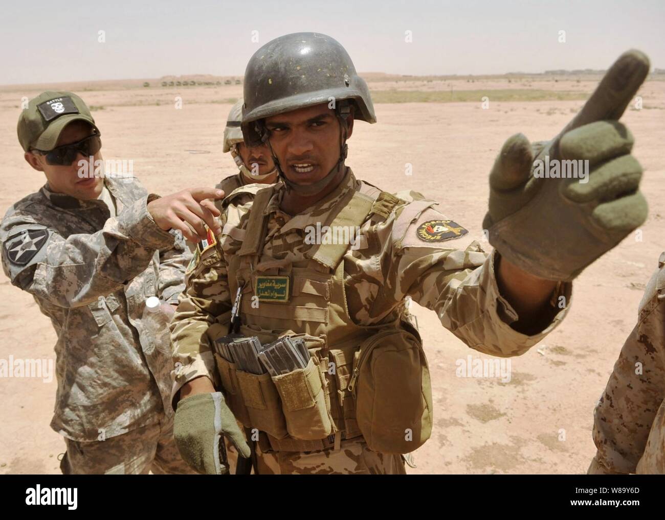 Us Army 1st Lieutenant J.D. Caddell (links), von der Bravo Company, 5 Bataillon, 20 Infanterie Regiment, 3 Stryker Brigade Combat Team, 2 Infanterie Division, erörtert die Manöver mit einen Team Leader aus dem irakischen Commando Bataillon, 18 Brigade vor einem Squad live-fire Übung an Kirkush Truppenübungsplatzes, der Provinz Diyala, Irak, am 27. Juni 2010. Stockfoto