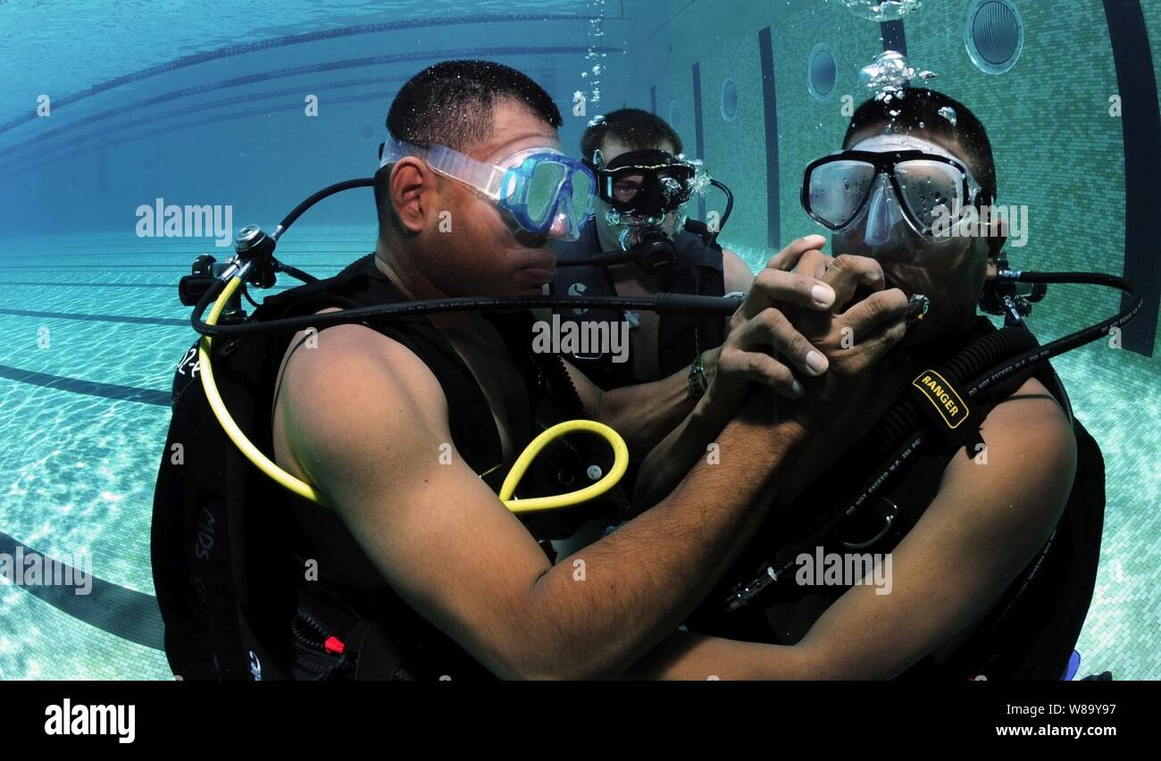 Panamasche diver Cpl. Edwin Sanchez (links) teilt seine Regler mit Cpl. Jamie Berchi (rechts) in Panama City, Panama, am 12.08.17., 2010. U.S. Navy Taucher zu Unternehmen 2-6, Mobile Tauchen und Bergung Einheit 2 zugeordneten durchgeführt SCUBA Einarbeitung vor gemeinsame Operationen auf See. Mobile Tauchen und Bergung Einheit 2 beteiligte sich an Marine Diver - südliche Partnerschaft Station, eine multinationale Partnerschaft Engagement für Interoperabilität und Partner nation Kapazität durch tauchen Operationen zu erhöhen. Stockfoto