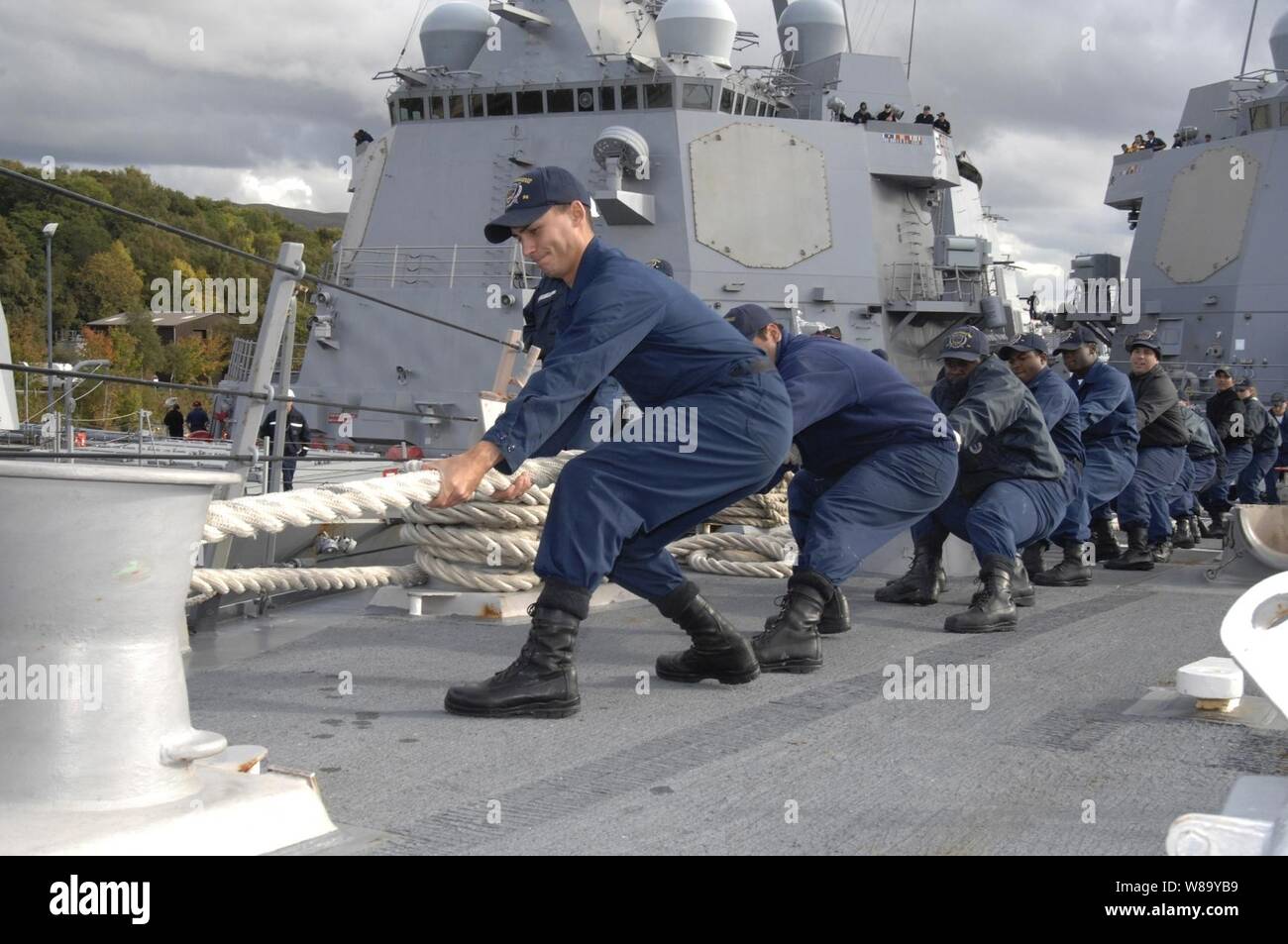 Us-Marine Seeleute an Bord der Lenkwaffen-zerstörer USS Bainbridge (DDG96) Haul in einem verankerungsleine während Liegeplatz des Schiffes in Faslane, Schottland, Sept. 30, 2010. Die Bainbridge bereitet sich in gemeinsamen Krieger 10-2, einer multinationalen Übung für Interoperabilität zwischen alliierten Seestreitkräfte zu verbessern und die Vorbereitung der teilnehmenden Crews Operationen während der Bereitstellung kombiniert zu beteiligen. Stockfoto