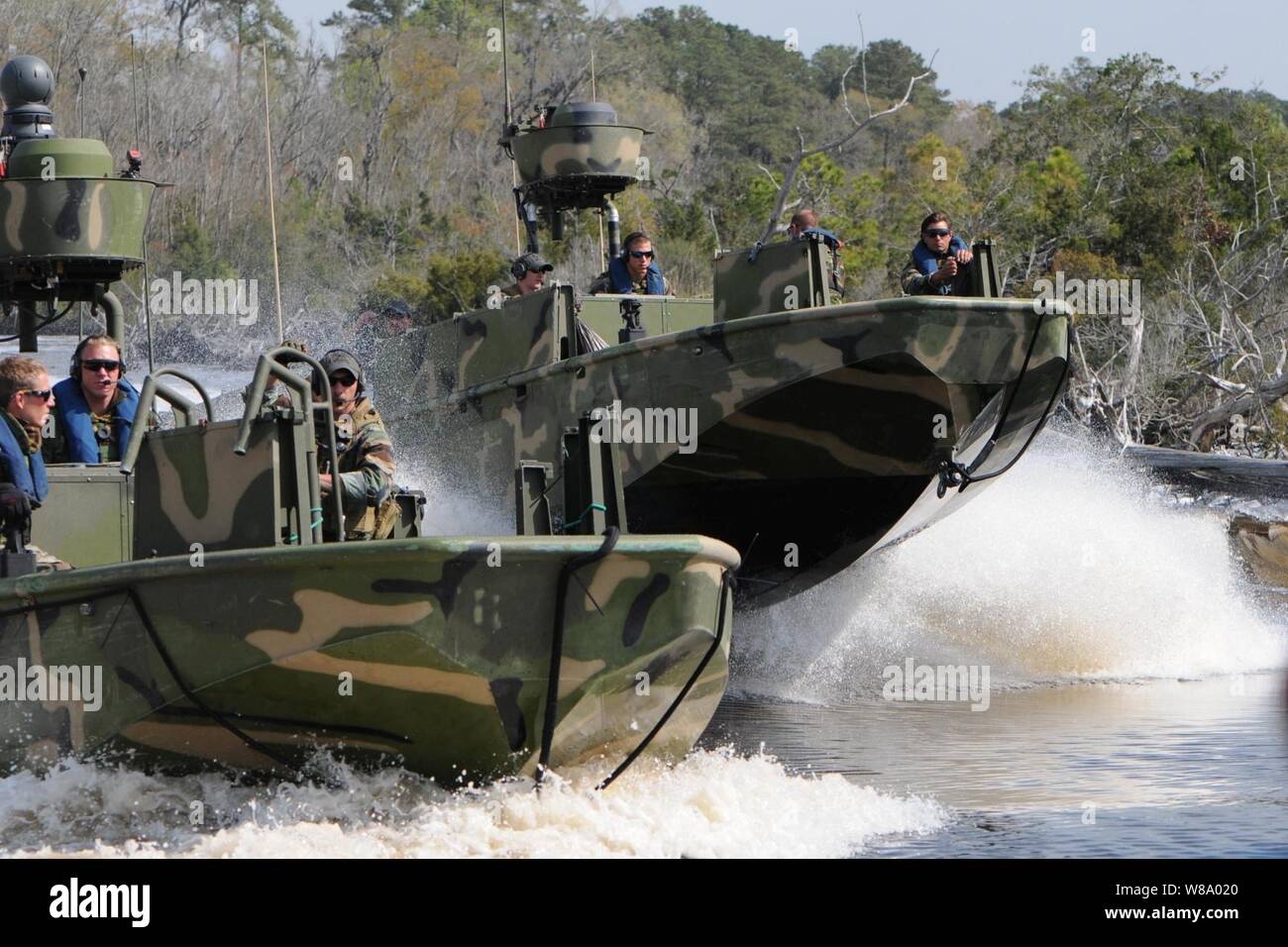 Matrosen zu Riverine Squadron 3 zugeordnet und Marines aus der Königlich Niederländischen Marine Corps ein Recht echelon Manöver in riverine Angriff Boote während einer dreiwöchigen Cross-training Taktiken auszutauschen und Fähigkeiten verfeinern in Camp Lejeune, N.C., am 22. März 2011. Stockfoto