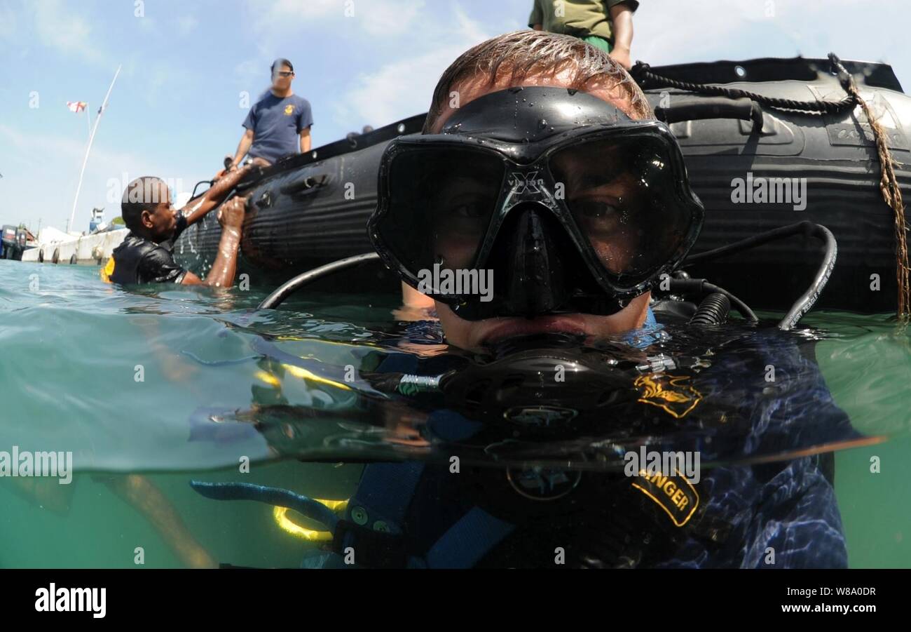 U.S. Navy Petty Officer 2. Klasse Justin McMillen, auf Mobile Tauchen und Bergung Einheit 2 zugewiesen, Oberflächen nach einem Tauchgang mit einem Mitglied der jamaikanischen Küstenwache zur Unterstützung der Marine Diver-Southern Partnerschaft Station aus Port Royal, Jamaika, am 22. Juli 2011. Südliche Partnerschaft Station ist eine jährliche Bereitstellung von US-Schiffe, die in den Bereich der US Southern Command der Verantwortung in der Karibik und in Lateinamerika. Das Ziel der Übung besteht die gemeinsame Nutzung von Informationen mit Marinen, Küstenwachen und zivilen Dienstleistungen in der gesamten Region. Stockfoto