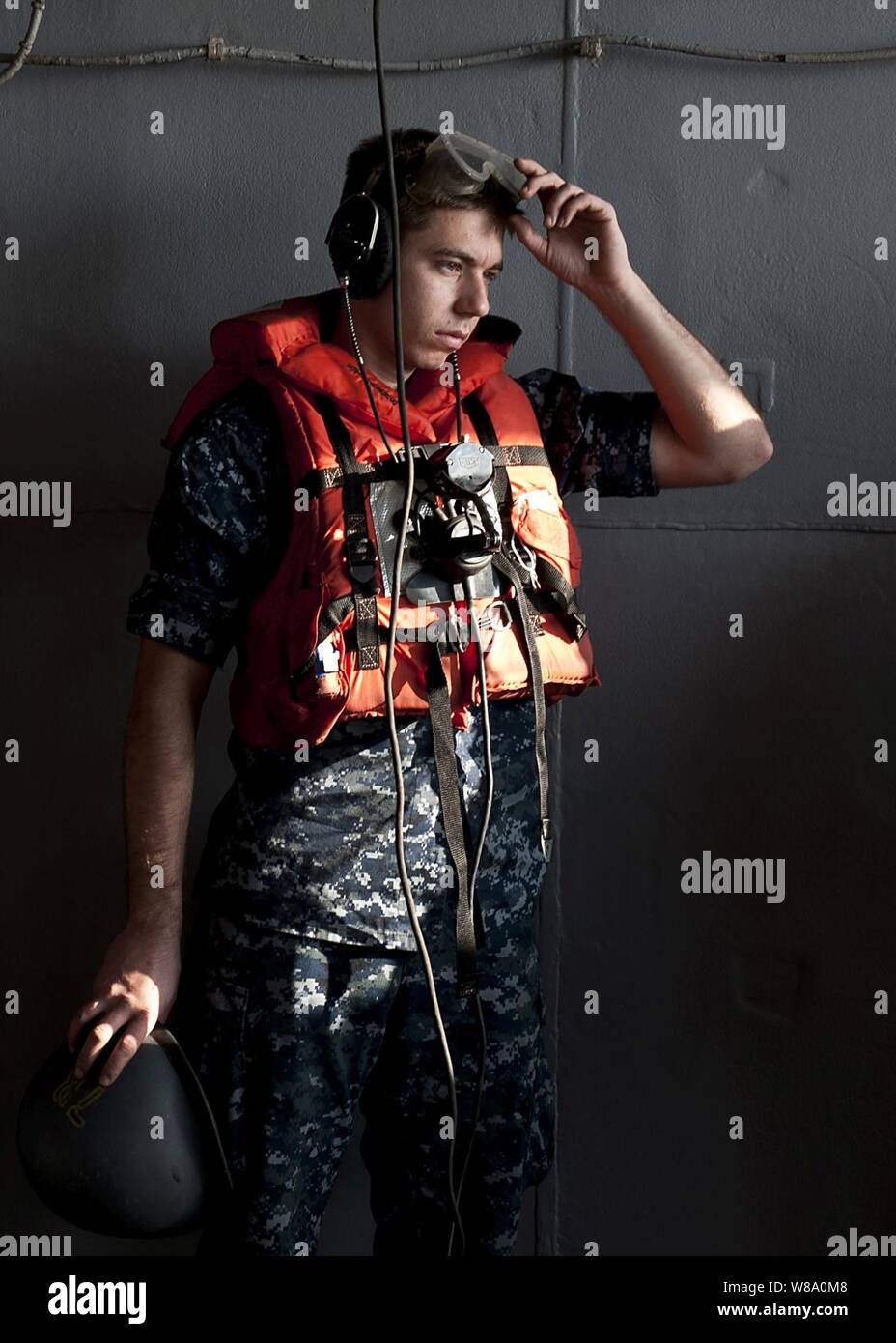 Seaman Seth Coulter anzieht, Schutzausrüstung, bevor eine Auffüll-anforderung auf See an Bord der Flugzeugträger USS John C Stennis (CVN 74) im Arabischen Meer am Dez. 29, 2001. Die John C Stennis ist in die USA 5 Flotte Verantwortungsbereich Durchführung Maritime Security Operations und Einsätze im Rahmen der Operation Enduring Freedom eingesetzt. Stockfoto