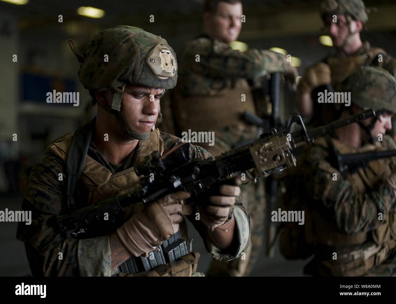 .S. Marine Corps Sgt. Alex Sanchez, mit der 11 Marine Expeditionary Unit, verwendet eine M4 Carbine Waffe Fehlfunktion Bohrer im Hangar Bucht des Amphibious Assault ship USS Makin Island (LHD8) in den Pazifischen Ozean am Dez. 2, 2011 Praxis. Der Makin Island und der 11 Marine Expeditionary Unit werden in den USA 5 USA 7 Flotte Flotte und Verantwortungsbereich eingesetzt. Stockfoto