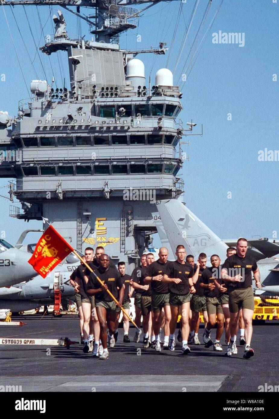 Die USS George Washington (CVN 73) Marine Loslösung läuft in Ausbildung über die Flight Deck des Flugzeugträgers während einer Ruhepause in den Flugbetrieb als Teil Ihrer körperlichen Fitness Regime am 30. März 1996. Die George Washington und seine Battle Group sind, die in den Persischen Golf, wo sie leiten Luft Patrouillen zur Unterstützung der Operation Southern Watch. Southern Watch ist der USA und der Koalition die Durchsetzung der no-fly-Zone im Süden des Irak. Stockfoto