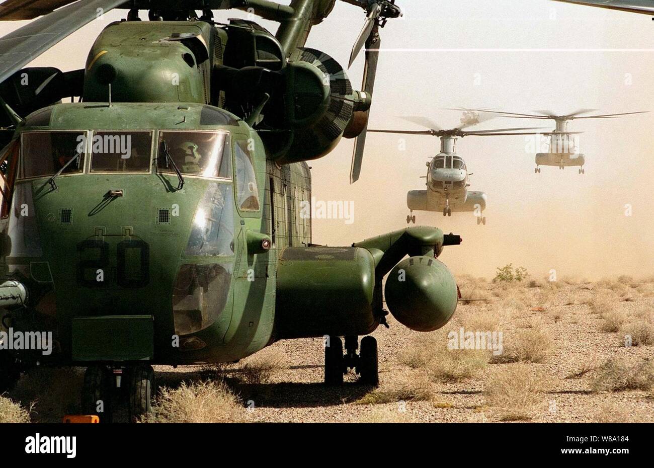 CH-46 Sea Knight Hubschrauber, rühren Sie sich eine Wolke aus Staub, wie Sie starten hinter einer CH-53 Sea Stallion auf der Fläche der Wüste in der Nähe von Yuma, Ariz., am 17. April 1997 während der Übung Wüste Punch. Wüste Punch ist eine simulierte Hubschrauber Angriff Mission mit über 60 Hubschrauber aus neun Staffeln von Marine Flugzeuge Gruppe 16. Die Hubschrauber der Marine Corps Air Station El Toro und Tustin, Kalifornien gestartet, und rendezvoused, die in den ausgewiesenen Landing Zone außerhalb Yuma. Stockfoto