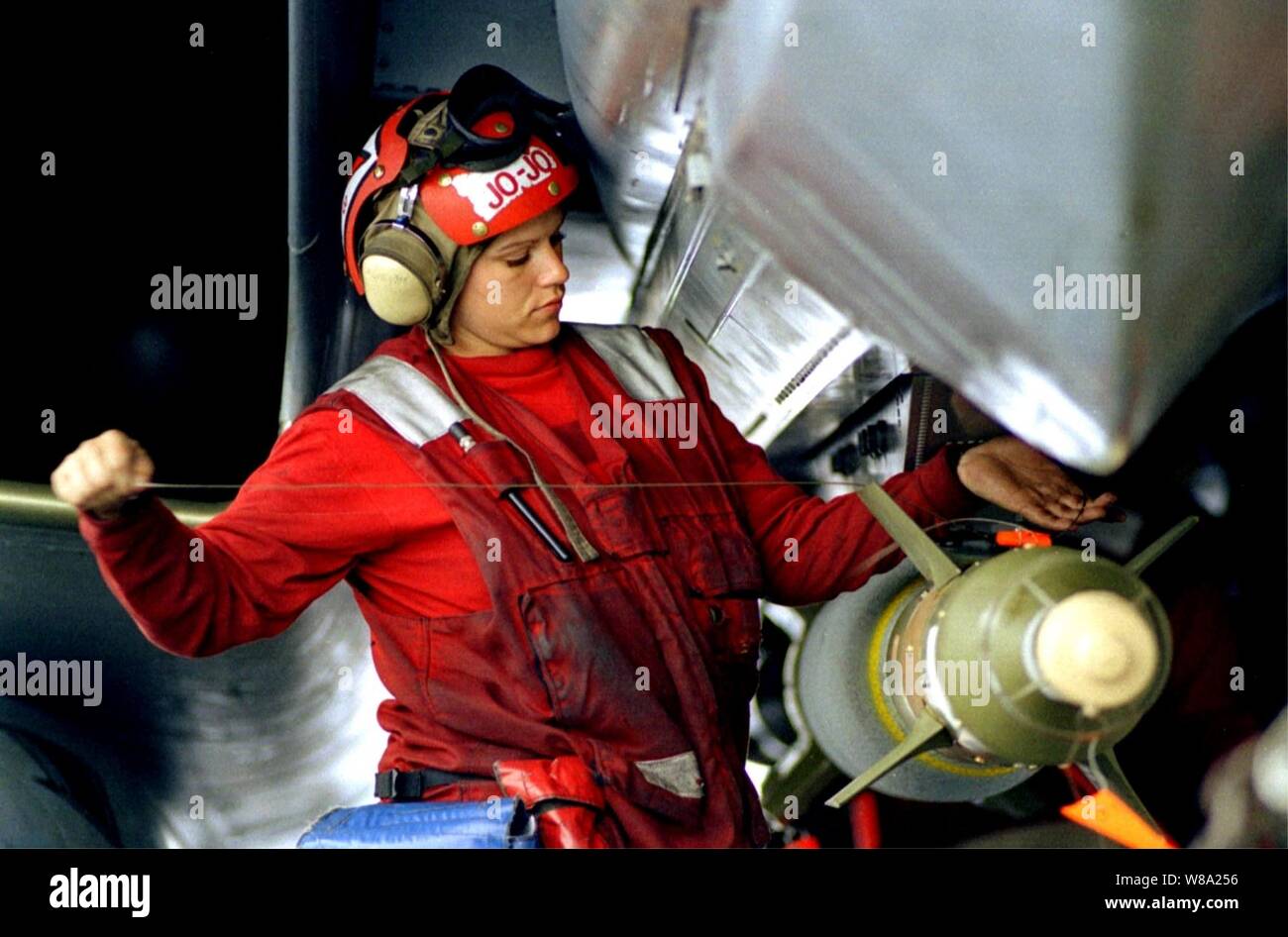 Ein U.S. Navy Aviation ordnanceman gilt die endgültige Verkabelung zu einer GBU-24 Laser-guided Bomb zu einer F-14 Tomcat befestigt auf dem Flugdeck der USS Theodore Roosevelt (CVN 71) am 4. Mai 1999. Roosevelt und seine eingeschifft Carrier Air Wing 8 sind, die in der Adria zur Unterstützung der NATO-Operation "Allied Force", das ist die Luft, die Operation gegen Ziele in der Bundesrepublik Jugoslawien. Stockfoto