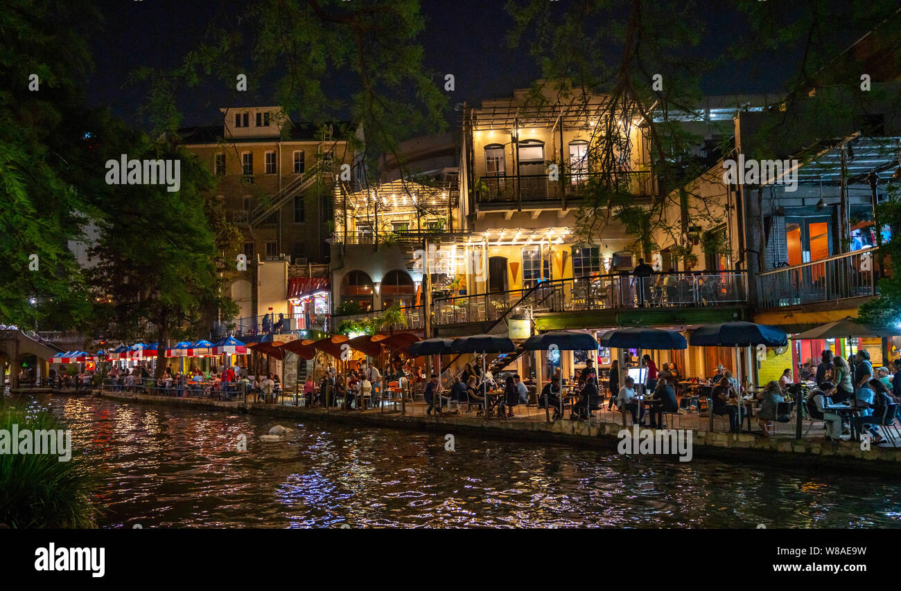 San Antonio River Walk in der Nacht mit bunten Restaurant Terrassen voller Touristen, die das Nachtleben. Stockfoto
