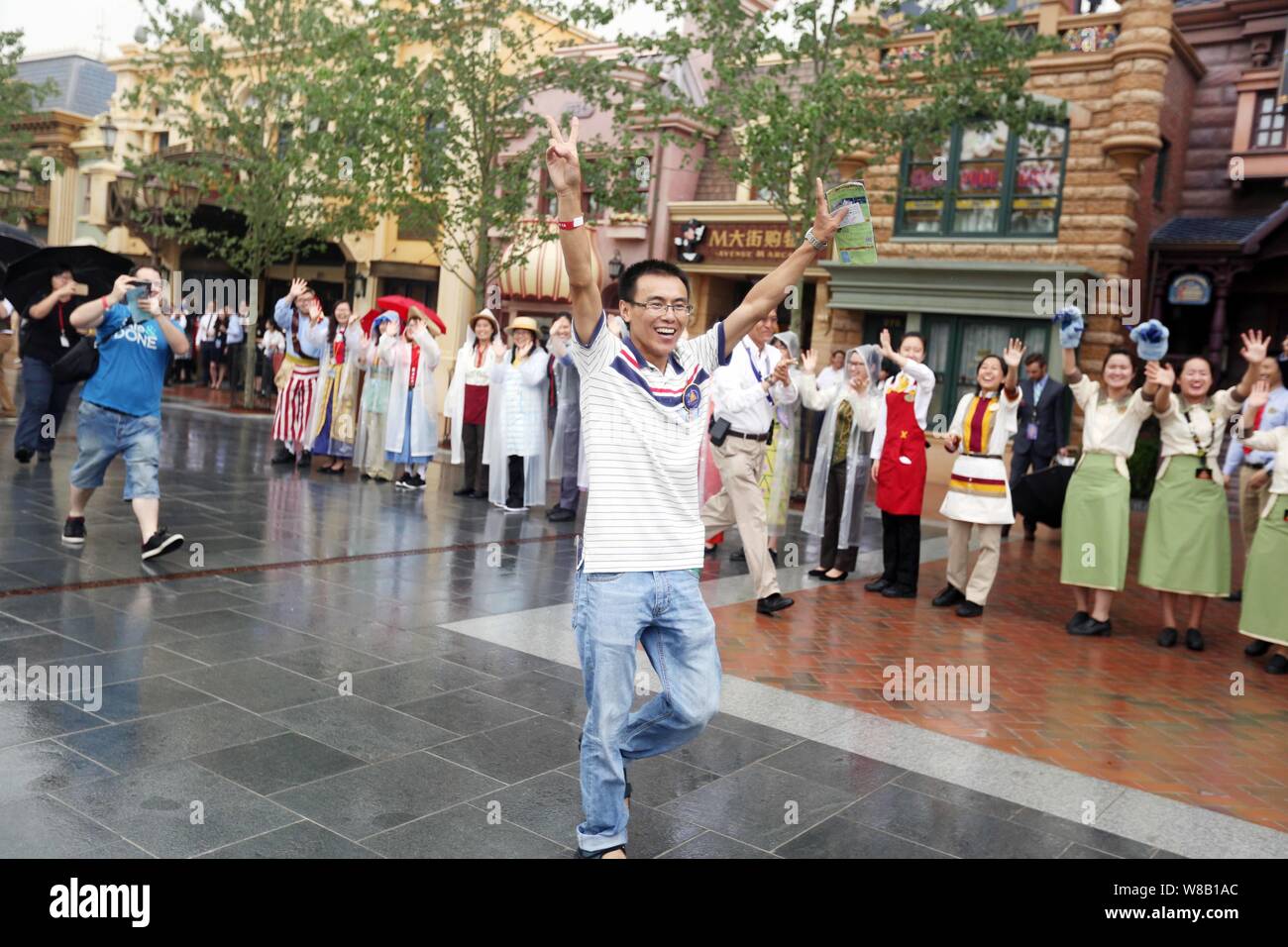 Der erste Gast zeigt Finger Zeichen des Sieges die Leute nach der Eingabe der Shanghai Disneyland an der Shanghai Disney Resort in Pudong, Sh Grüße Stockfoto