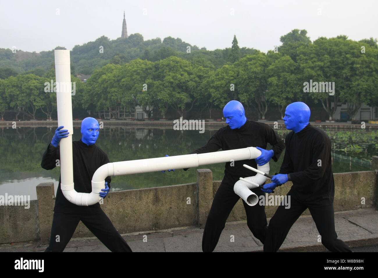 Künstler aus der Blue Man Group durchführen mit einem Stück verworfen Rohr Umweltschutz in der Nähe der zerstörten Brücke auf dem West See zu fördern. Stockfoto