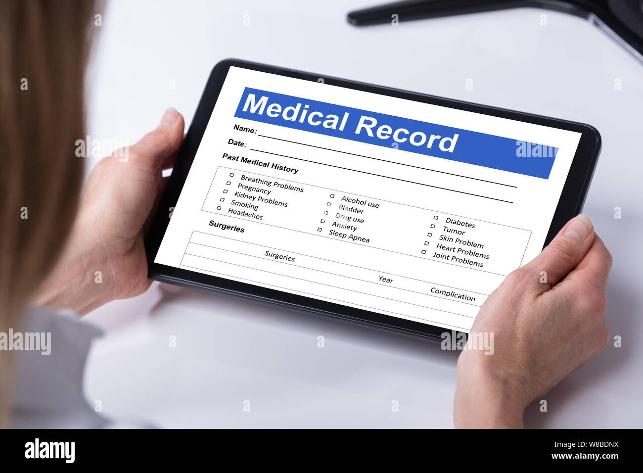 In der Nähe der weiblichen Arzt suchen Patienteninformationen Form auf digitalen Tablet über Schreibtisch Stockfoto